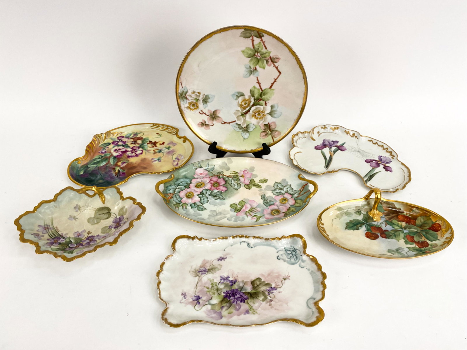 (7) ANTIQUE PORCELAIN PLATTERS: All nicely decorated. Of French manufacture, about half Limoges. Dimensions: (Largest) L 15" x W 10" Condition: Some rubbing to the gold. No visible damages.