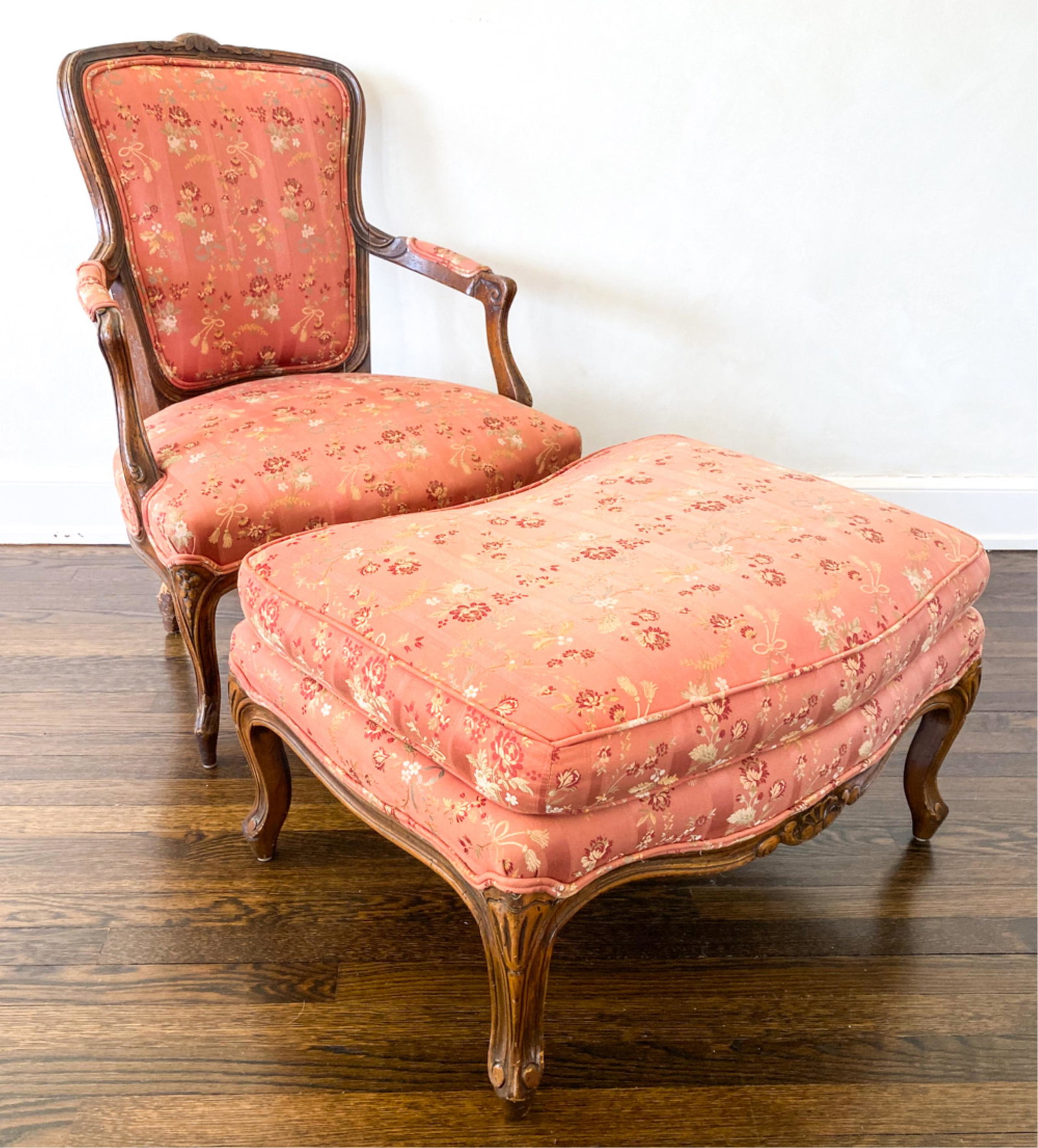 LOUIS XV-STYLE FAUTEUIL CHAIR & OTTOMAN: Carved frame with cabriole legs. Dimensions: (Chair) H 36" x W 28" x D 26" x SH 15.25" Condition: One back leg with dog chewing damage. In need of restoration. Sun fading to upholstery.