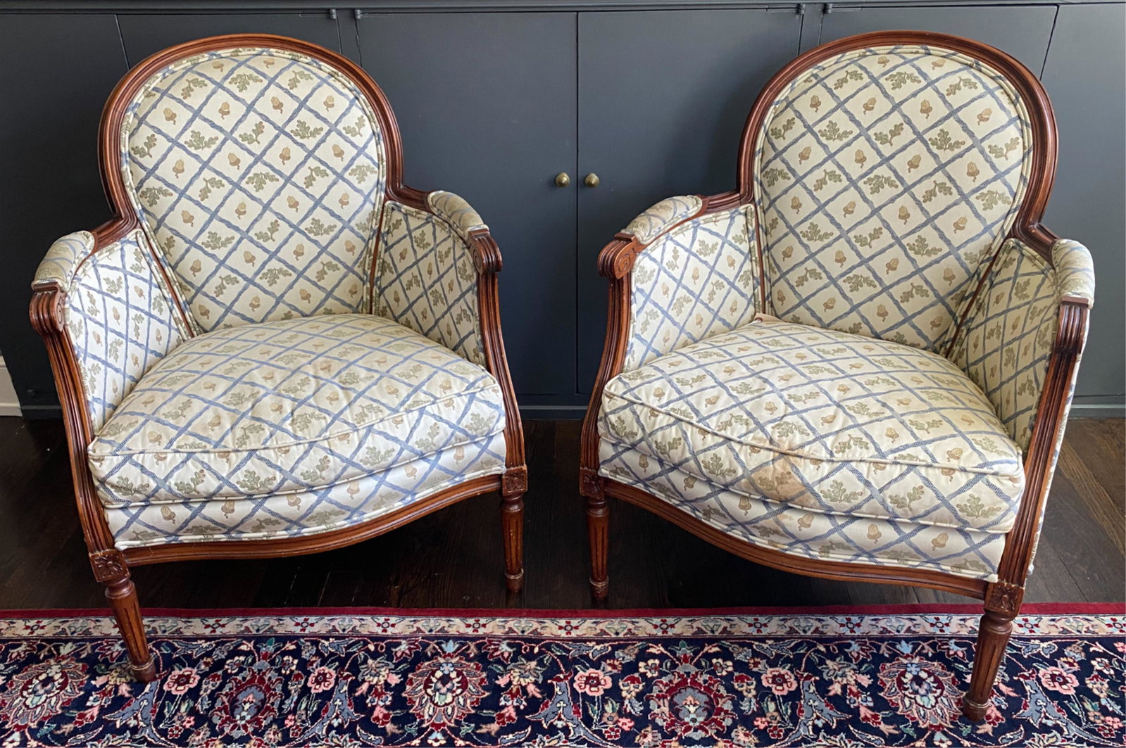 PAIR OF STICKLEY FRENCH-STYLE BERGERE CHAIRS: Upholstered in oak and acorn motif fabric. With Stickley label underneath. Dimensions: H 33.5" x W 26.25" x D 24" x SH 17" Condition: Some joint separation. Soiling to upholstery; in need of re-uphols