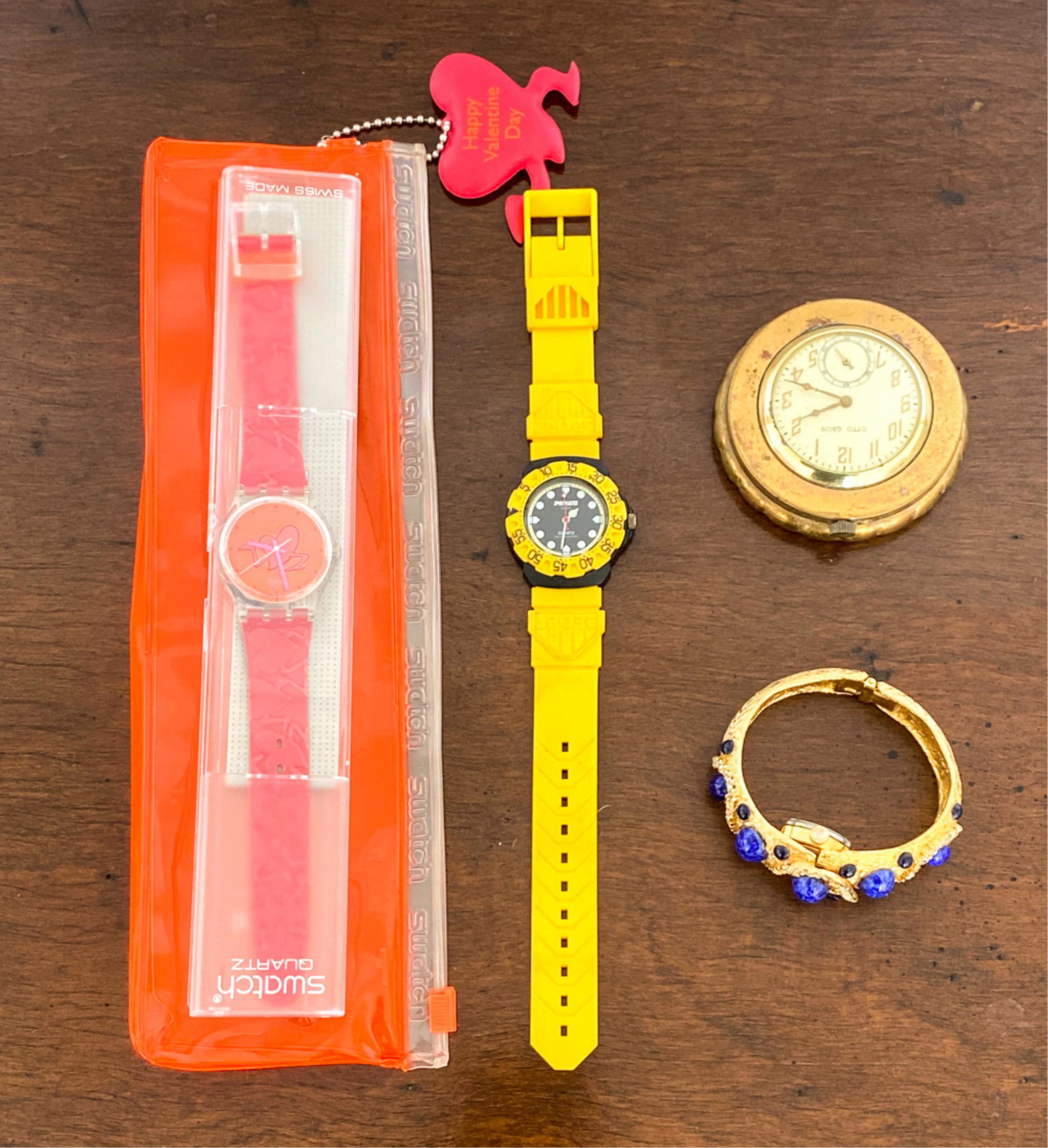 GROUPING OF WATCHES & POCKET WATCH INCL. SWATCH: Including Swatch watch, new in bag, Geneva hidden watch bracelet, Sportmaster watch, and Otto Grun pocket watch. Dimensions: (Sportmaster) L 10" x W 1.5" Condition: Not tested. Pocket watch with some 