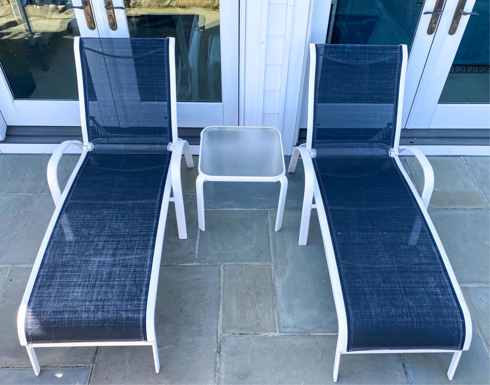 PAIR OF OUTDOOR PATIO CHAISES & SIDE TABLE: No labels. Chaises with adjustable backs. Dimensions: (Chaise, back fully up) H 36" x W 28.5" x D 54" x SH 14.5" Condition: Wear consistent with outdoor use including some scuffs, finish wear. Seats w