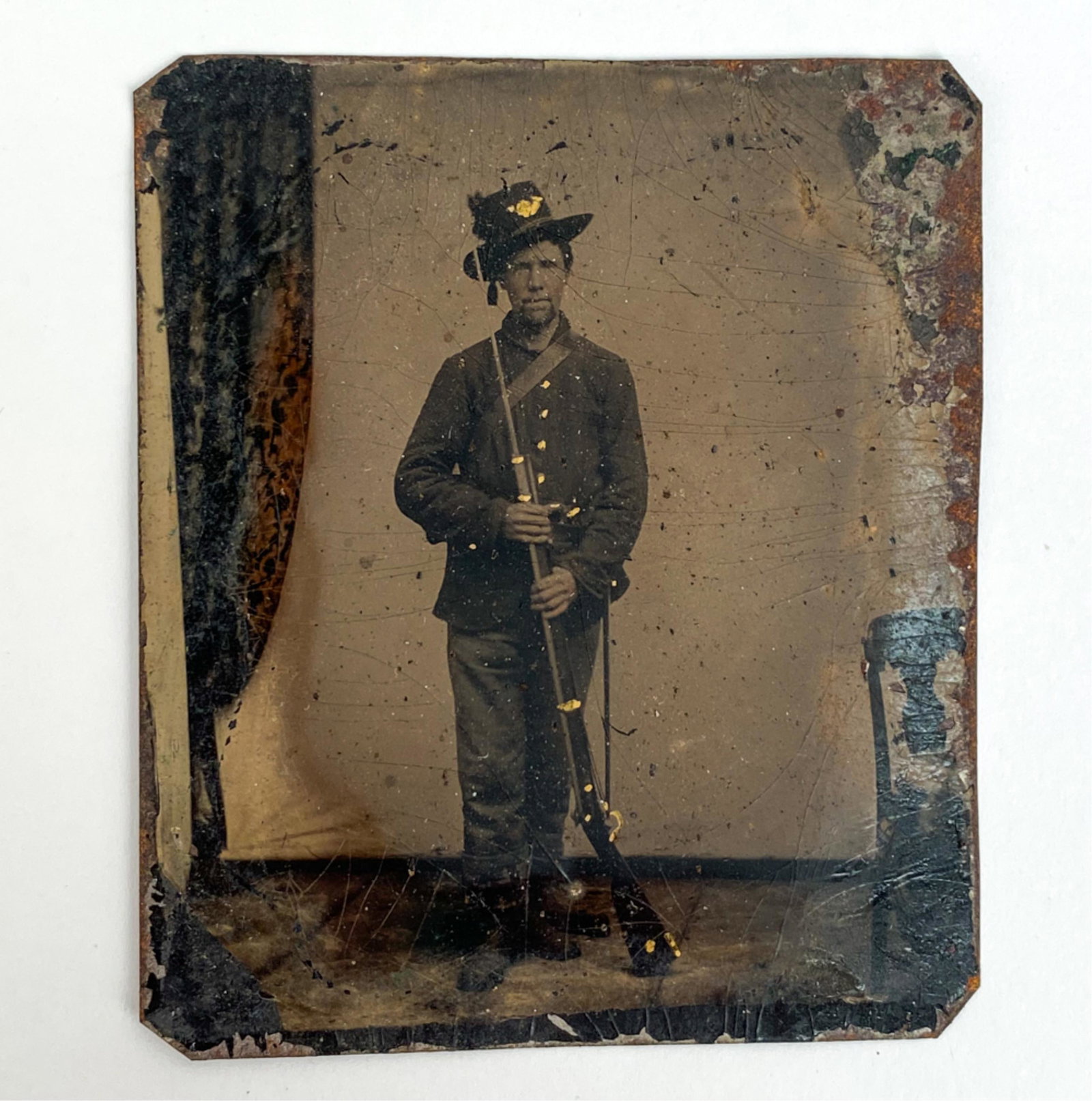 1/6 PLATE TINTYPE UNION SOLDIER W/ RIFLE: Standing full figure with bayonet affixed. Dimensions: H 3.25" x W 2.5" Condition: Damages around edges. Clipped corners. Rusting.