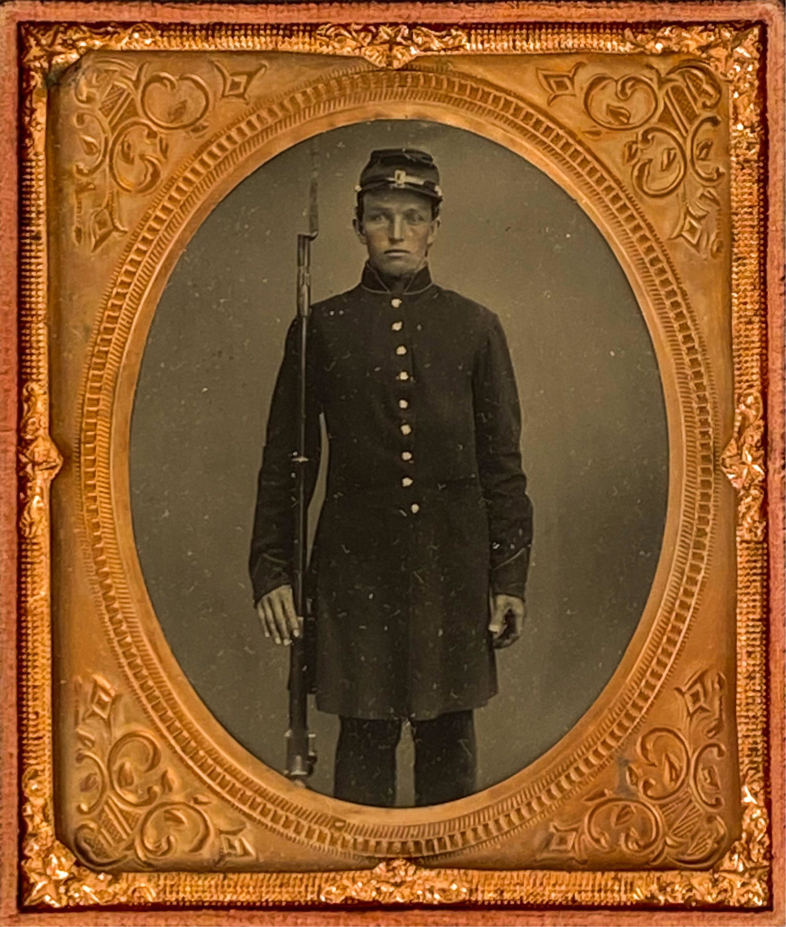1/6 PLATE TINTYPE OF 3/4 LENGTH UNION SOLDIER: Union soldier standing with his rifle, bayonet affixed. In case. Dimensions: (Case) H 3.75" x W 3.25" Condition: Case with minor wear. Image strong. Few small defects to the glass.