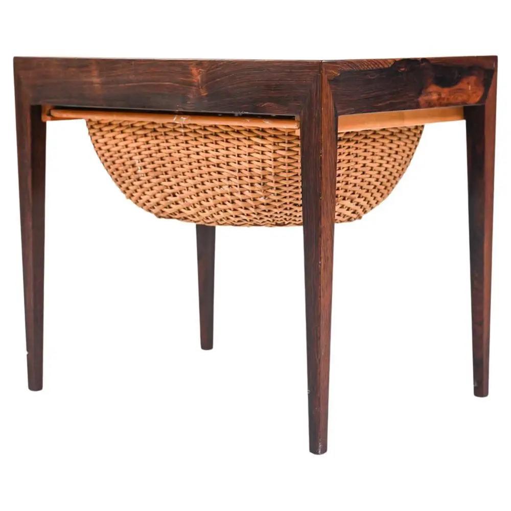 SEVERIN HANSEN FOR HASLEV ROSEWOOD SEWING TABLE: Add a touch of unexpected texture to your home with this sewing-style side table in rosewood, which features a slide-out wicker basket and secret hidden side drawer for ample storage. Designed by Seve