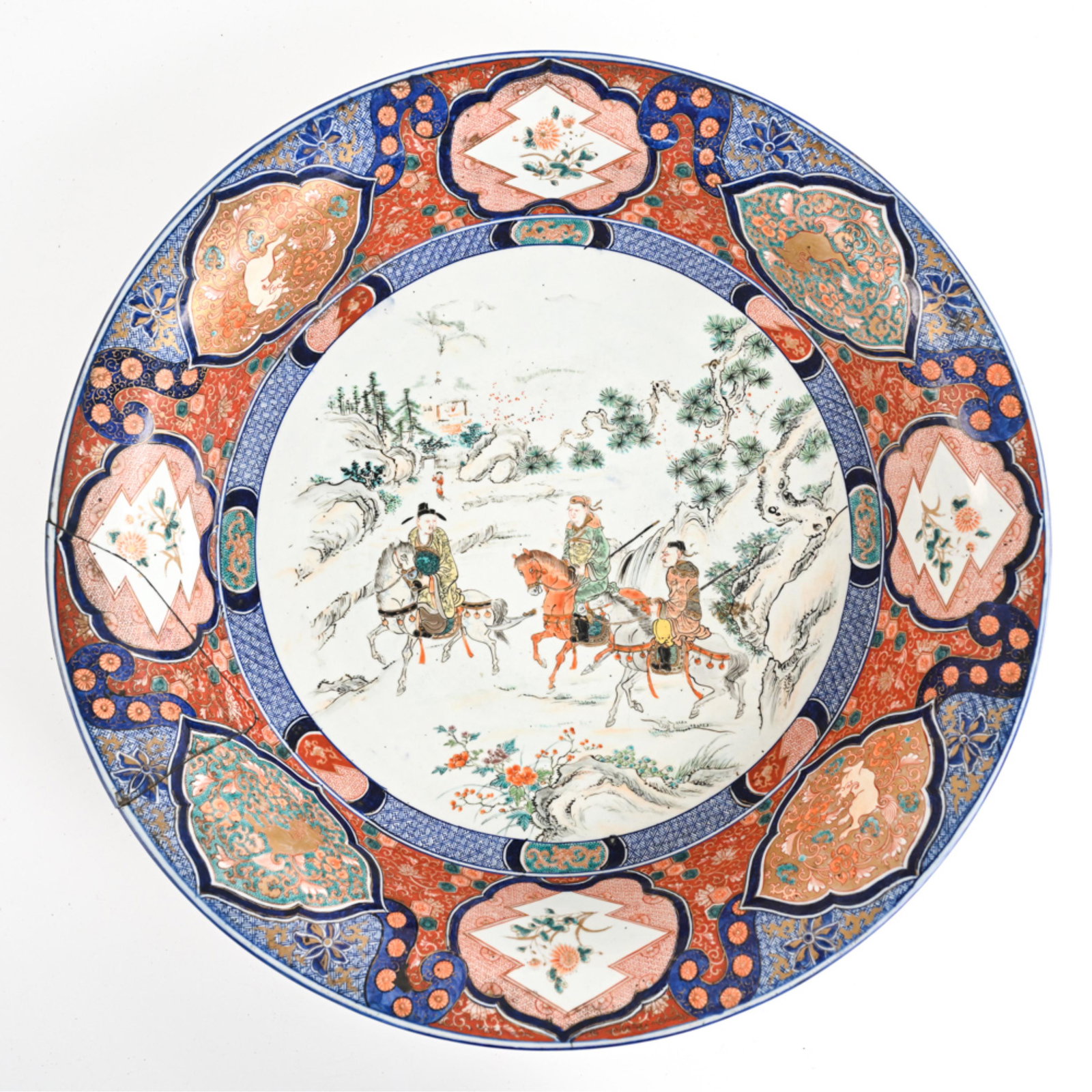 MONUMETNAL ANTIQUE IMARI PORCELAIN CHARGER BOWL: Floral mark underneath. Dimensions: H 6" x Dia. 25.5" Condition: One large repaired break to rim, about 7.5" wide, with a couple chips along seam. Otherwise showing normal light surface wear and rubs 