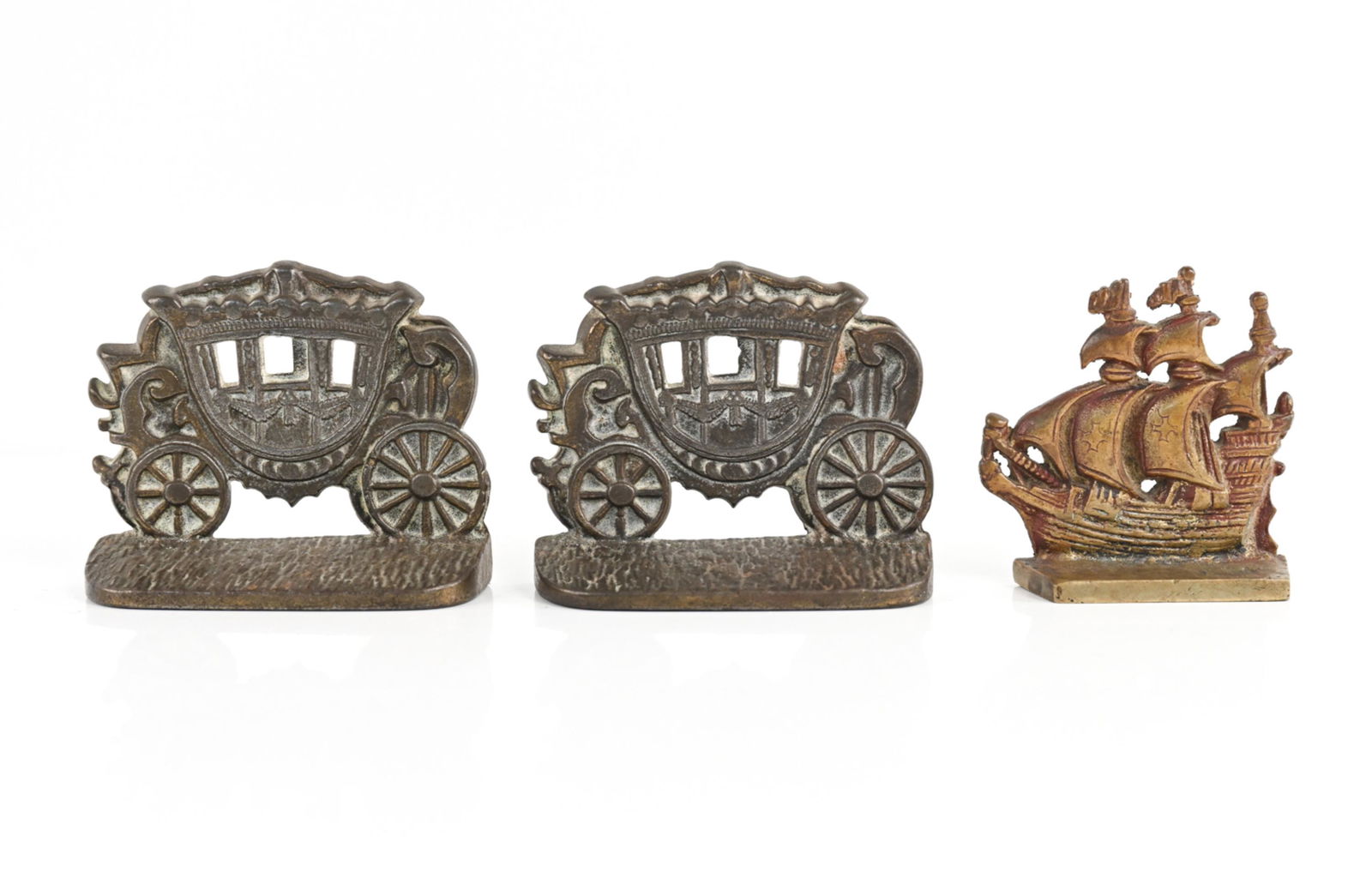 (3) VINTAGE METAL DOORSTOPS: Two in carriage form, one ship form. All unmarked. Dimensions: (Carriage) H 4.25" x W 5.25" x D 2" Condition: Wear consistent with age and use including some tarnish, rubbing.
