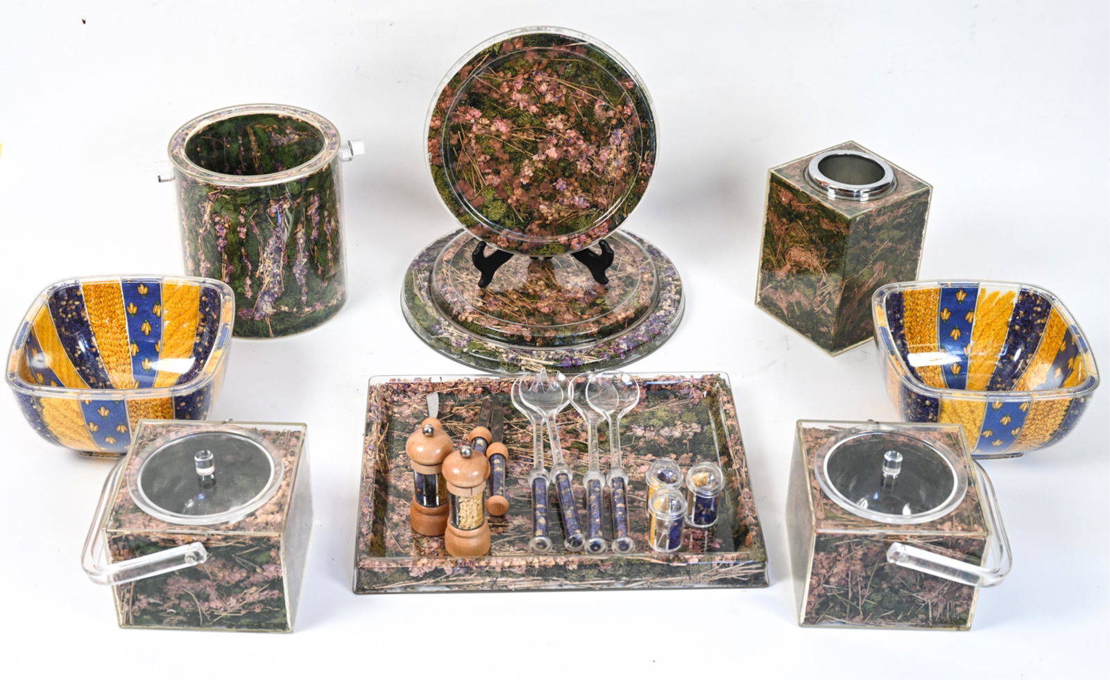 GROUPING OF DRIED FLOWER SERVINGWARE: Grouping of clear plastic servingware with dried flowers and grains encased. Including champagne bucket, trays, salad bowls and serving utensils, pepper mills, ice buckets, salt shakers, and wine cool