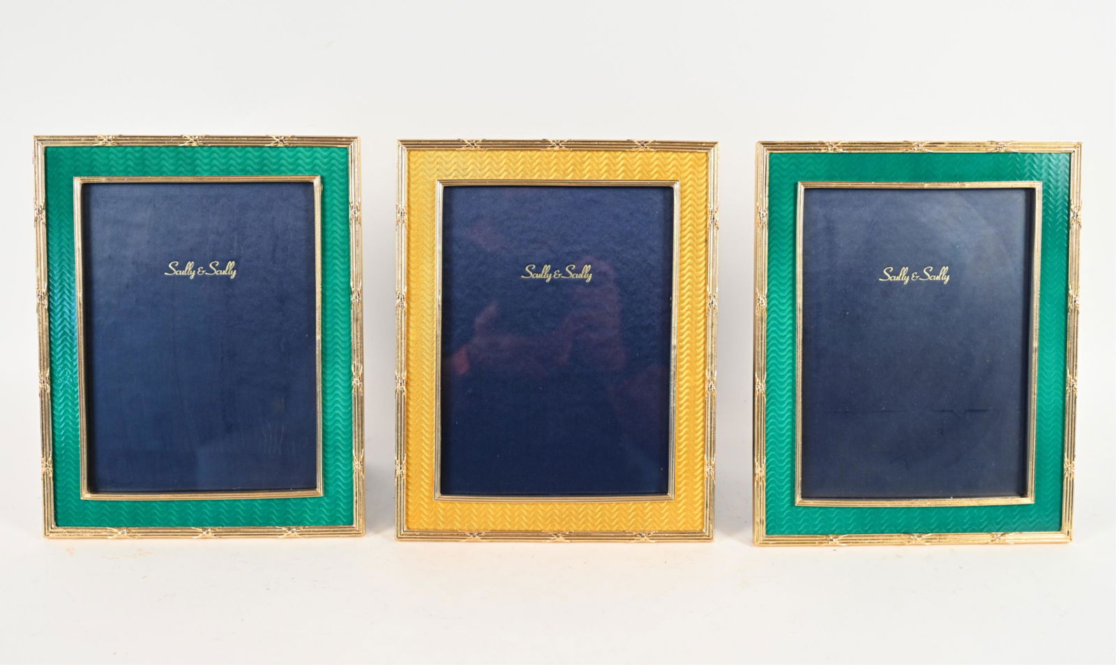 (3) SCULLY & SCULLY ENAMEL PICTURE FRAMES: (3) guilloche enamel picture frames, two green, one yellow. All by Scully & Scully. Dimensions: (Overall) H 10" x W 8", (Opening) H 7.75" x W 5.75" Condition: No issues to note.