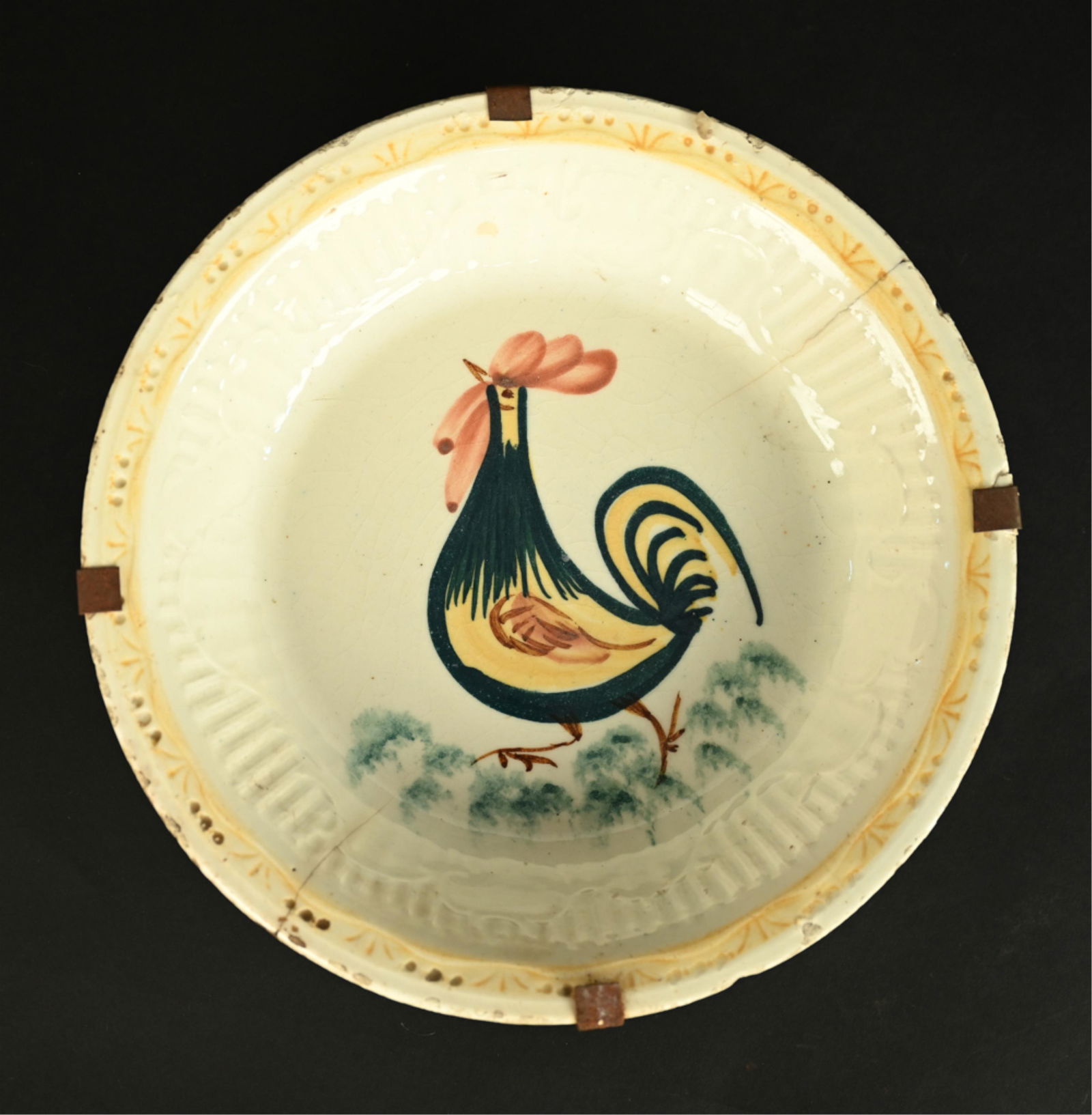 ANTIQUE MAJOLICA ROOSTER BOWL: Stamped Manises with deer mark and indistinct date underneath, possibly an imitation mark. Dimensions: H 2.25" x Dia. 11.25" Condition: Bowl with cracks and chips/breaks to edges, crazing and surface