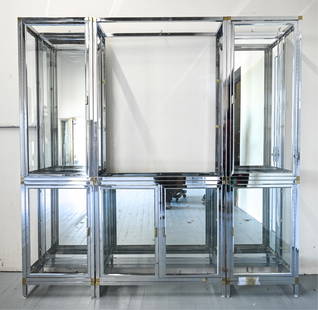 MODERN CHROME, BRASS & GLASS DISPLAY CABINET: Modern chrome and glass display case with square brass accents, in the manner of Romeo Rega or Renato Zevi. Cabinet doors have brass pulls. Corners of stacked cabinets have square brass accents. 6 pie