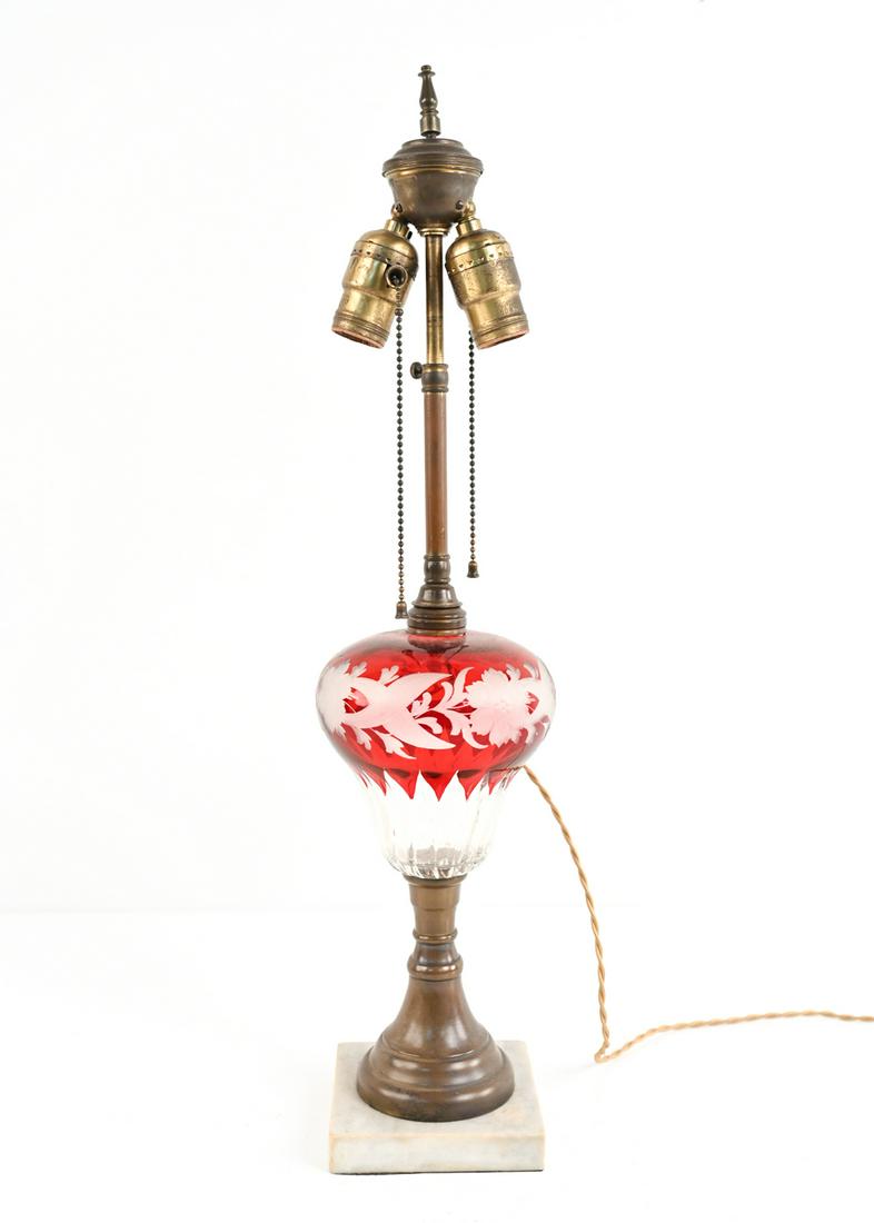 ANTIQUE CRANBERRY CUT-TO-CLEAR GLASS LAMP: On marble base. Apparently unmarked. Dimensions: H (to finial) 24.5" x Dia. 5.5" Condition: Wiring not tested. A few surface scuffs and marks, patina to brass mounts, some rubbing to marble corners.