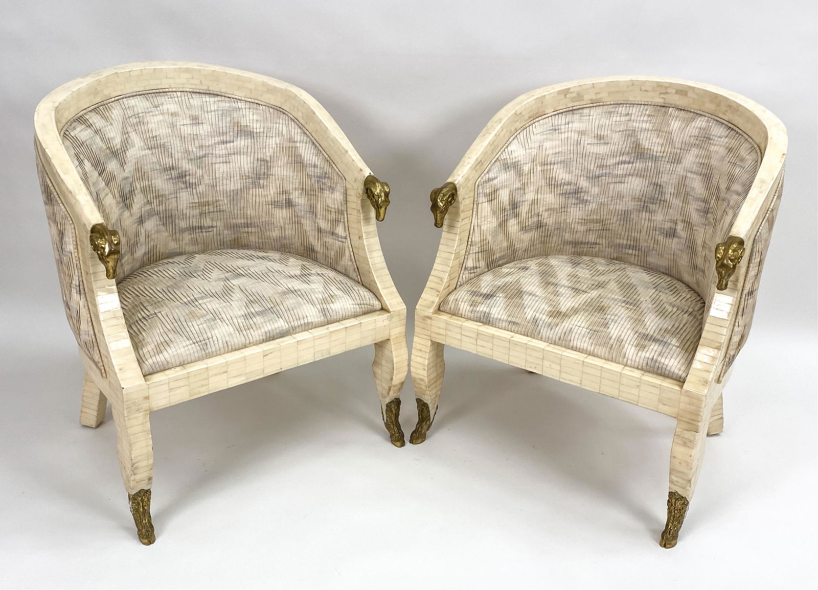 PAIR OF ENRIQUE GARCEL RAM'S HEAD ARMCHAIRS: Pair of mid-century, c. 1970's, lacquered & tessellated Neoclassical-style armchairs with brass ram's heads and feet. No labels. In pleated fabric. Dimensions: H 32.75" x W 26" x D 24" x SH 15.5" Cond