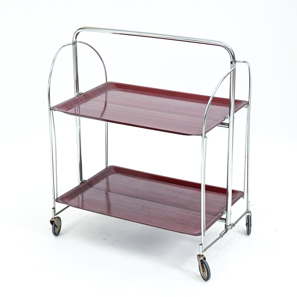GERMAN MID-CENTURY COLLAPSIBLE BAR CART: Collapsible faux-rosewood laminate and chrome bar cart. No labels. Dimensions: H 30.5" x W 27" x D 17" Condition: Scratches, scuffs, and surface marks. Dents to corners. S115