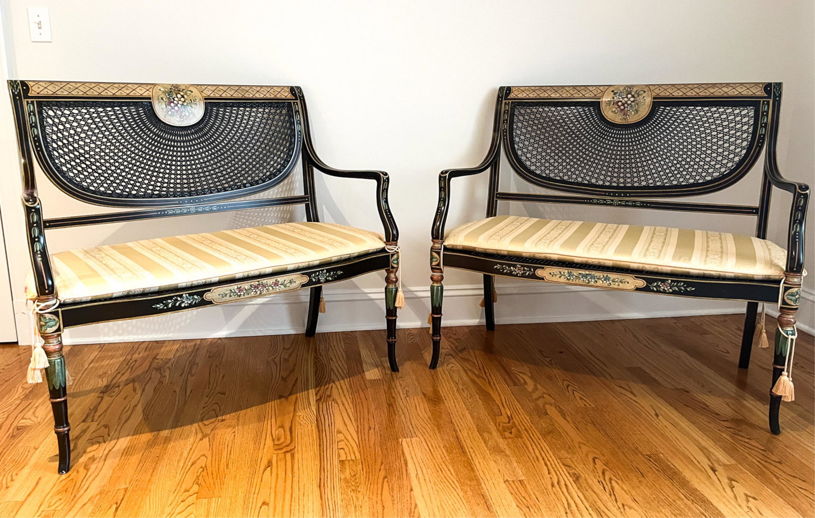 PAIR OF ENGLISH CANE AND PAINTED SETTEES: Dimensions: H 38" x W 43" x D 19" SH 18" Condition: Some soiling to cushion. Small breaks to caning. Some light rubs to paint.