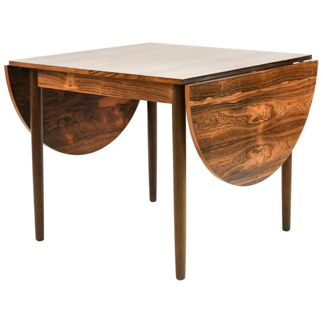DANISH ARNE VODDER-STYLE ROSEWOOD DINING TABLE: A gorgeous Danish midcentury dining table in the style of designer Arne Vodder. This table is expandable to accommodate a large family for daily use or many guests on special occasions. Crafted of hig