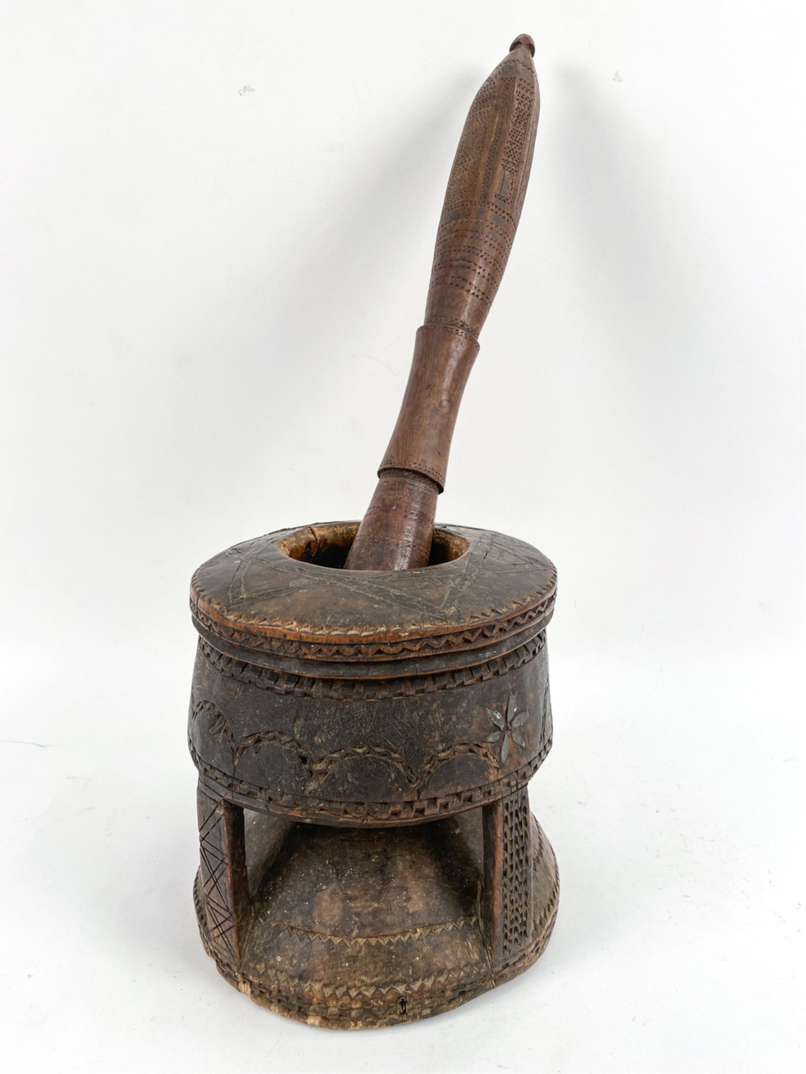 ETHNOGRAPHIC WOOD MORTAR & PESTLE: With carving. Sun details inlaid in brass and tin. Dimensions: (Mortar) H 10" x Dia. 9" Condition: Cracked to one side.