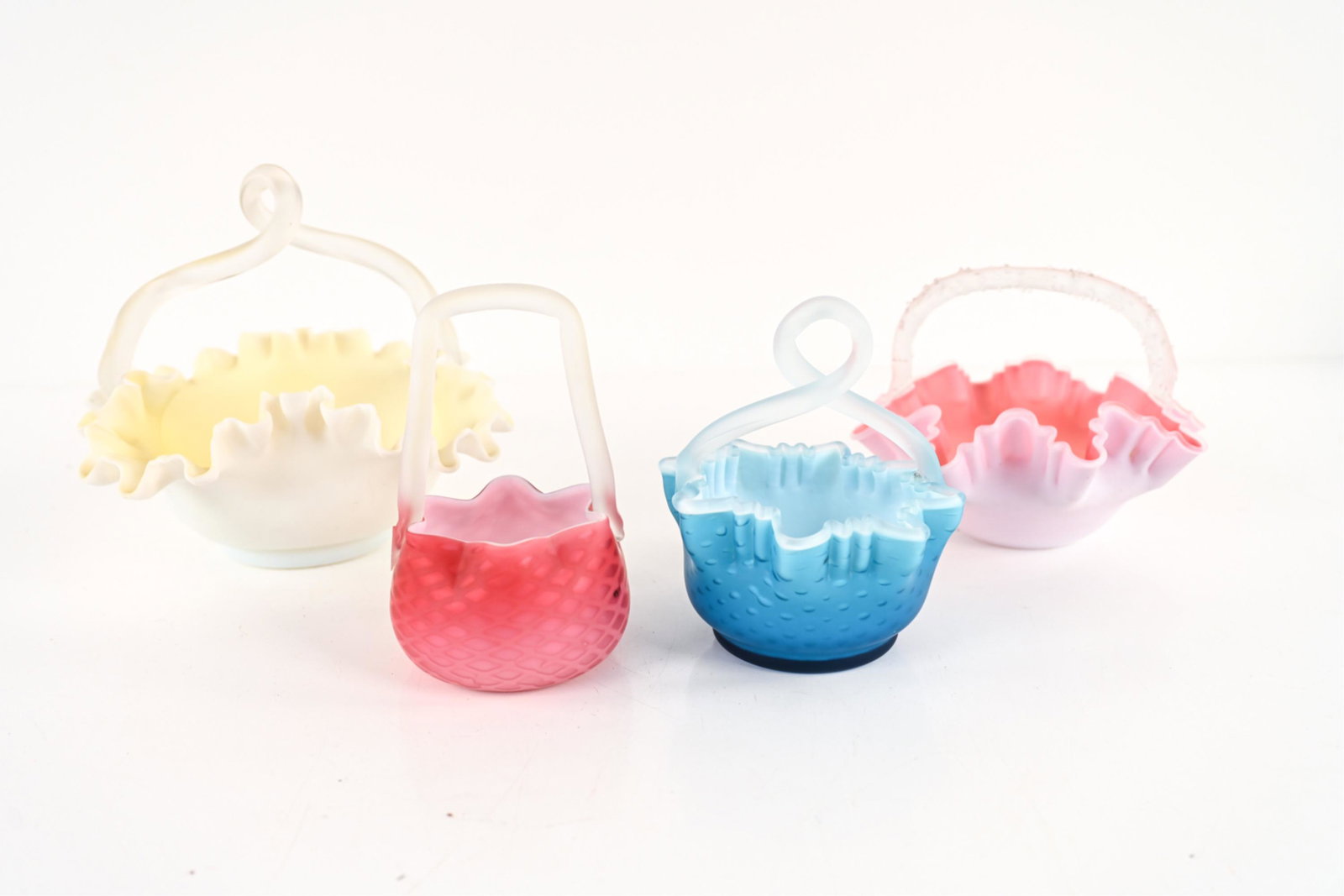 (4) RUFFLED SATIN ART GLASS BASKETS: Apparently unsigned. Dimensions: (Largest, yellow) H 9" x W 10" x D 10" Condition: Yellow and light pink baskets with a few scuffs and marks to exterior. Dark pink basket with one dark spot (an imperf