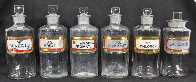 C. 1910 LABEL UNDER GLASS APOTHECARY BOTTLES: Group of six. Measures: 8.5" tall
