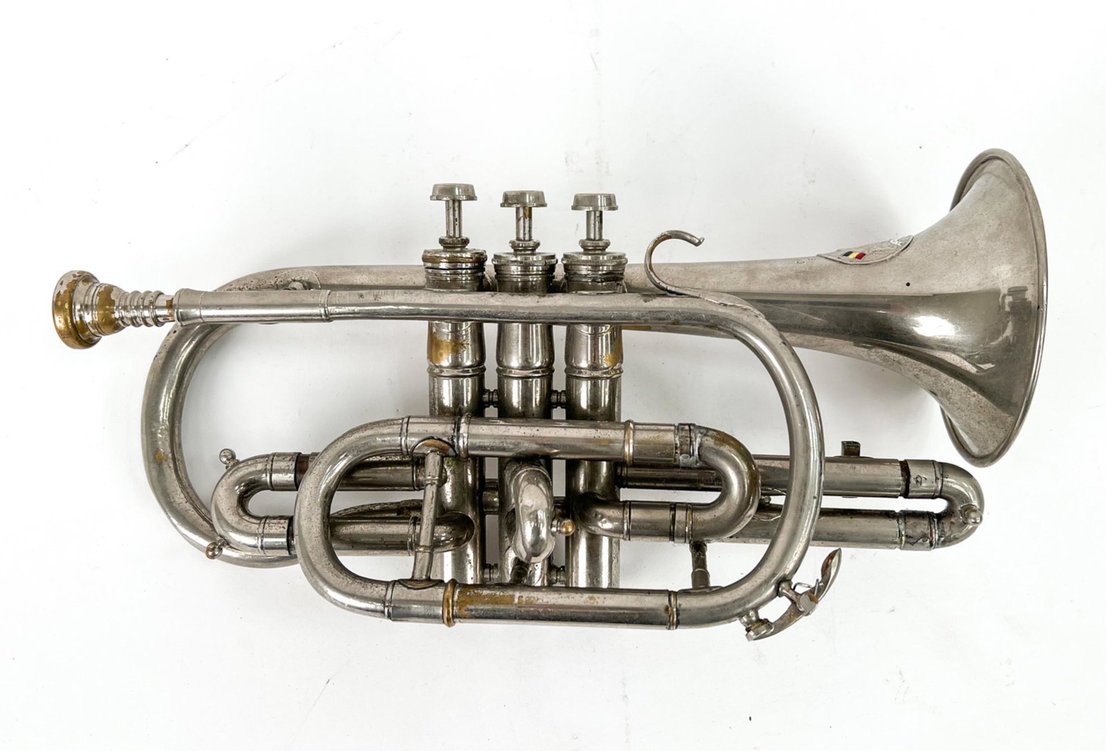 C. MAHILLON BELGIAN CORNET: Signed by C. Mahillon, Bruxelles. With enamel badge. Zinc coated brass. Dimensions: L 13" x W 6.5" x D 5" Condition: Some minor denting. Use wear to the silvered surface. Unplayed; untested.