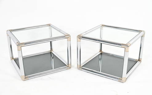 (2) MANNER OF MASCHERONI TUBULAR CHROME END TABLES: Pair of open cube end tables in tubular bent chrome, with brass-finished corners, clear glass tops and smoked glass bottom tiers. In the manner of John Mascheroni or Paul Tuttle, c. 1970's. Dimensions