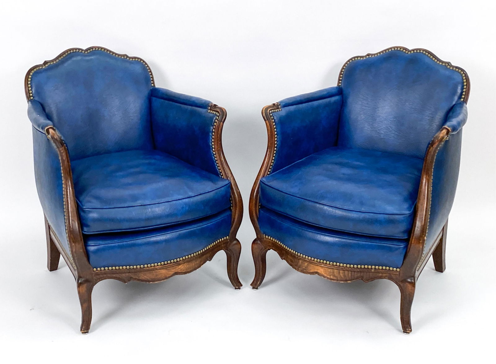 PAIR OF PETITE BERGERE CHAIRS: Appears to be oak with brass tacked blue faux leather. Dimensions: H 31.5" x W 22" x D 23" x SH 16" Condition: Wear and scuffs.