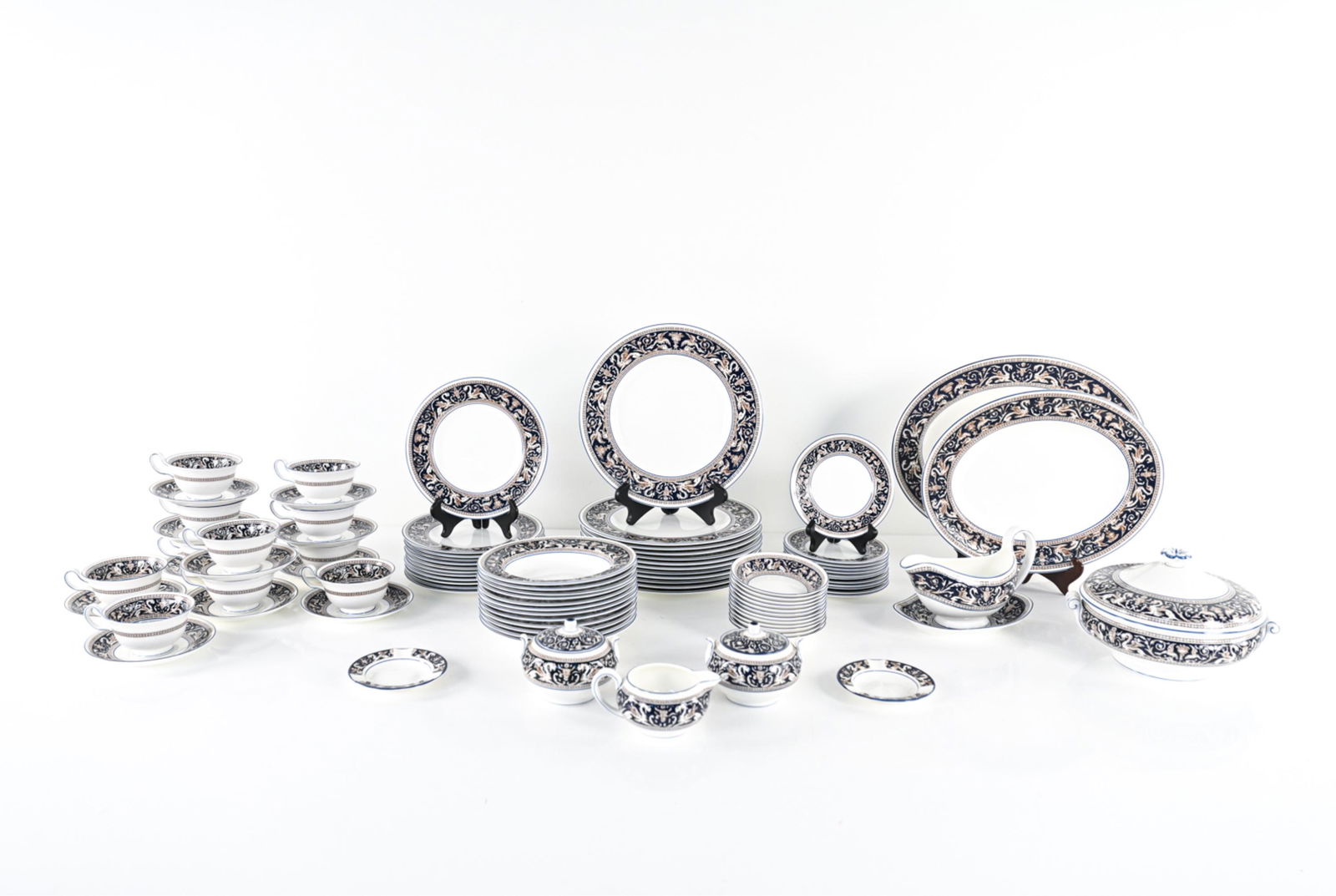 ENGLISH WEDGWOOD "FLORENTINE" BONE CHINA SERVICE: Vintage Wedgwood service from the "Florentine" pattern in dark blue; Made in England. Includes: (12) dinner plates, (12) salad plates, (12) bread & butter plates, (12) soup bowls, (12) fruit bowls, (1