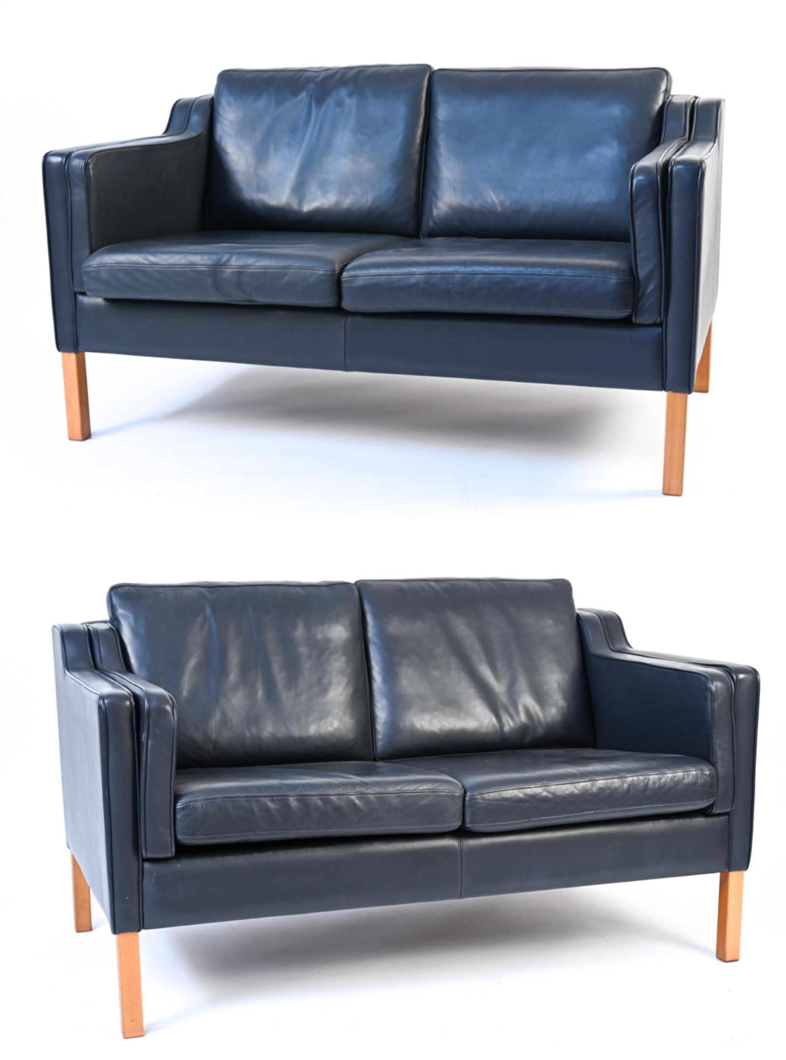PAIR OF DANISH MODERN STOUBY LEATHER SETTEES: Pair of dark blue leather loveseats in the style of Borge Mogensen. Dimensions: H 29.5" x W 55.5" x D 32" x SH 18" Condition: Showing very light wear consistent with occasional use; leather with a som
