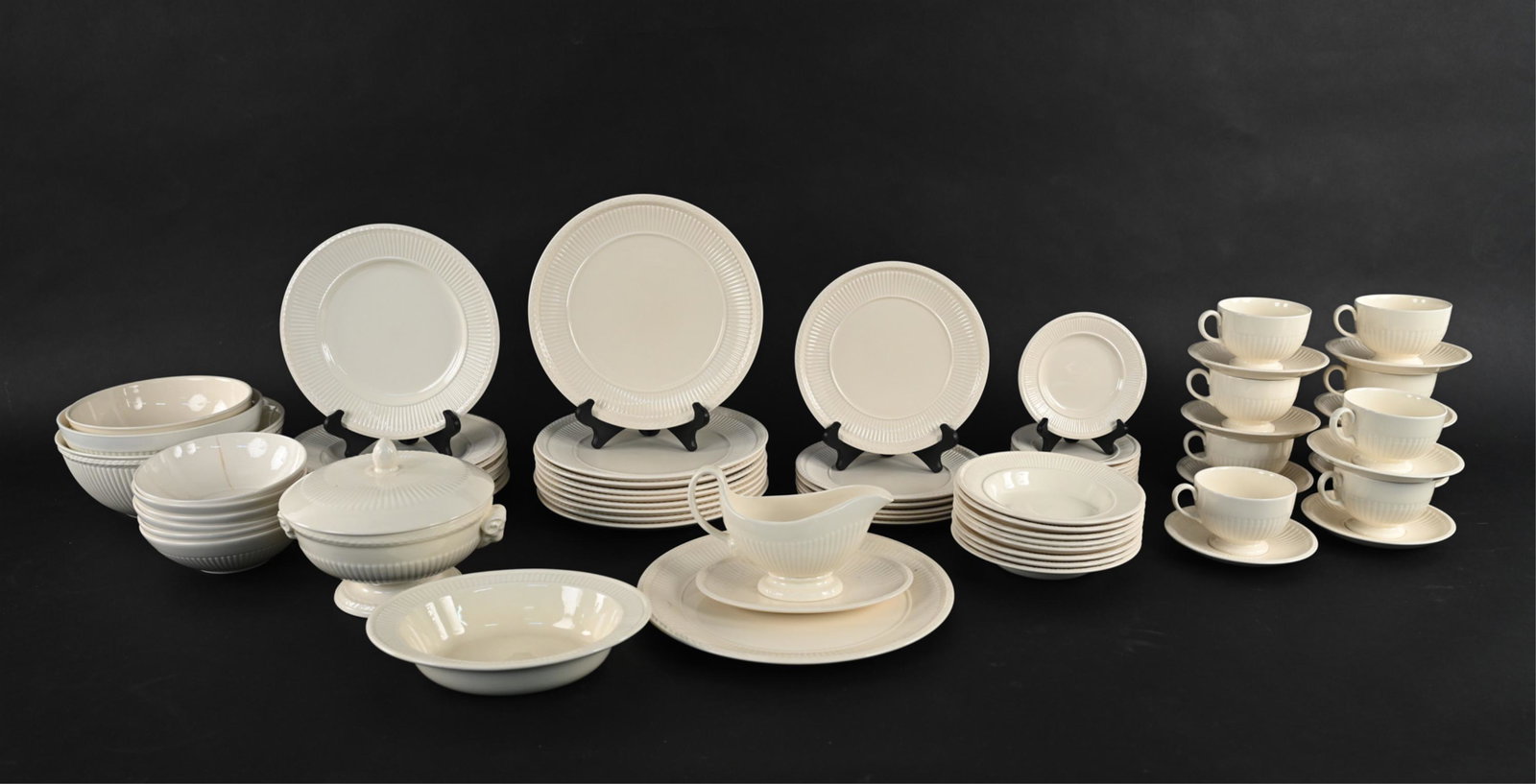 WEDGWOOD EDME PORCELAIN SERVICE: An assembled service consisting of both vintage (Made in England) and contemporary pieces from the "Edme" pattern by Wedgwood in off-white. Including: (9) charger plates, (8) dinner plates, (6) salad