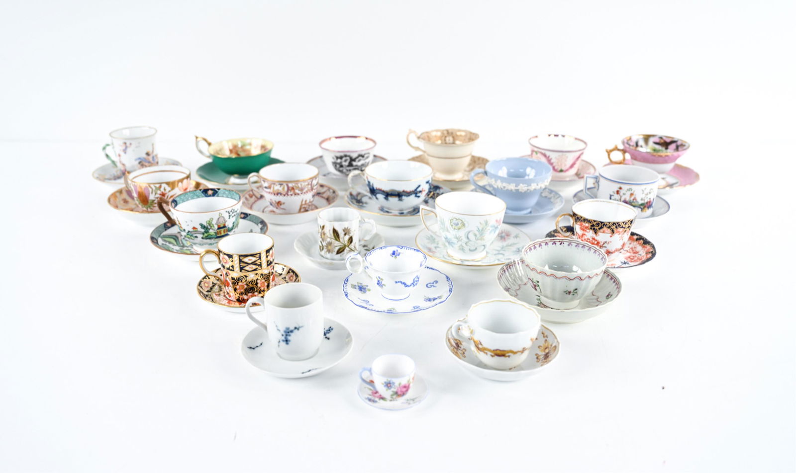 GROUPING OF TEA CUPS & SAUCERS INCL. CAPODIMONTE: (22) Cups and (21) saucers in total. Exquisite grouping of demitasse cups, teacups and saucers dating from the Late 18th Century to the 20th Century, including an antique Ginori Capodimonte bas relief