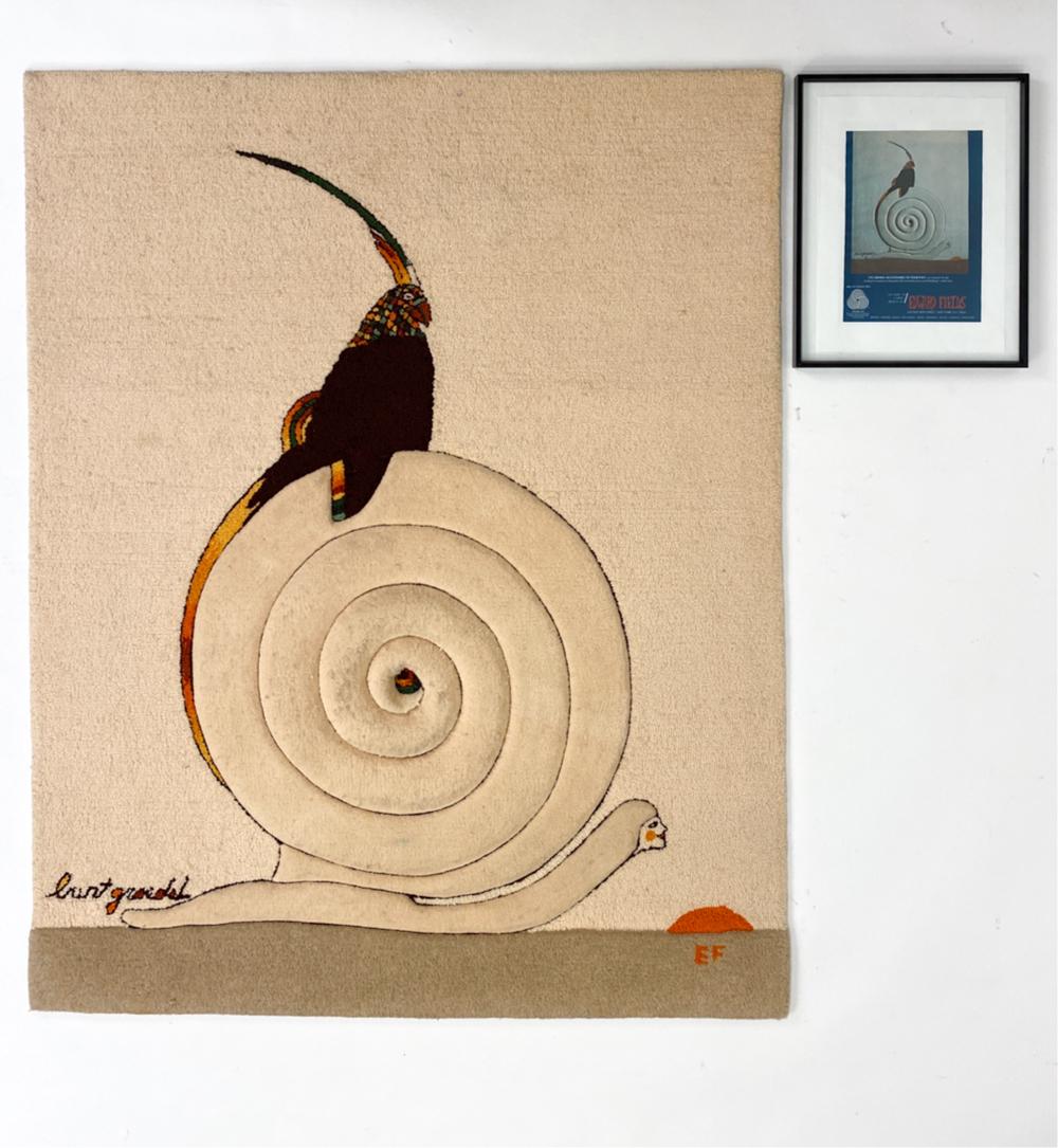 EDWARD FIELDS BURT GROEDEL RUG: Titled "I've Grown Accustomed to Your Pace." Rug plus framed advertisement with the rug. Rug with three-dimensional snail. Dimensions: (Rug) H 61" x W 48.5" Condition: Raised surfaces soiled.