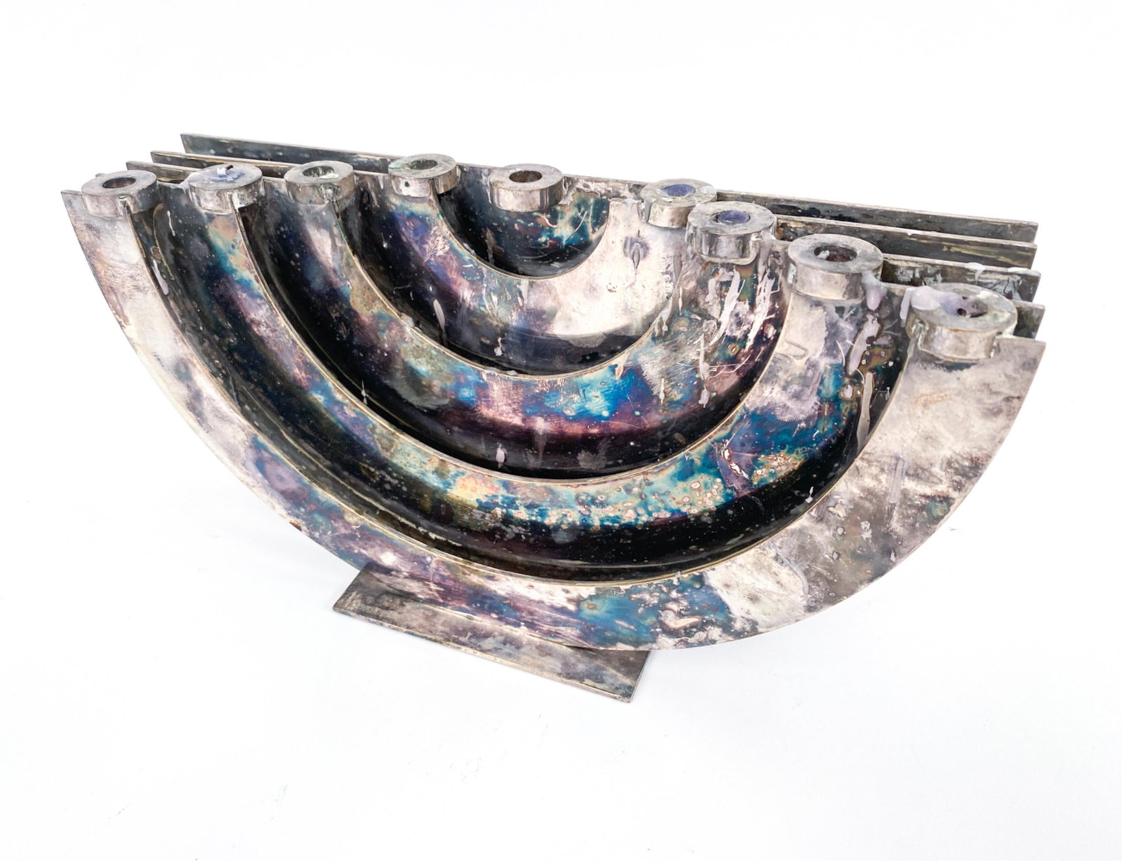 MODERNIST SILVEPLATE DOROTHY GUTFELD MENORAH: Signed Dorothy Gutfeld to lower left corner of base. Dimensions: H 5" x W 9.75" x D 3" Condition: Tarnish to silverplate. Wax remnants and signs of use.