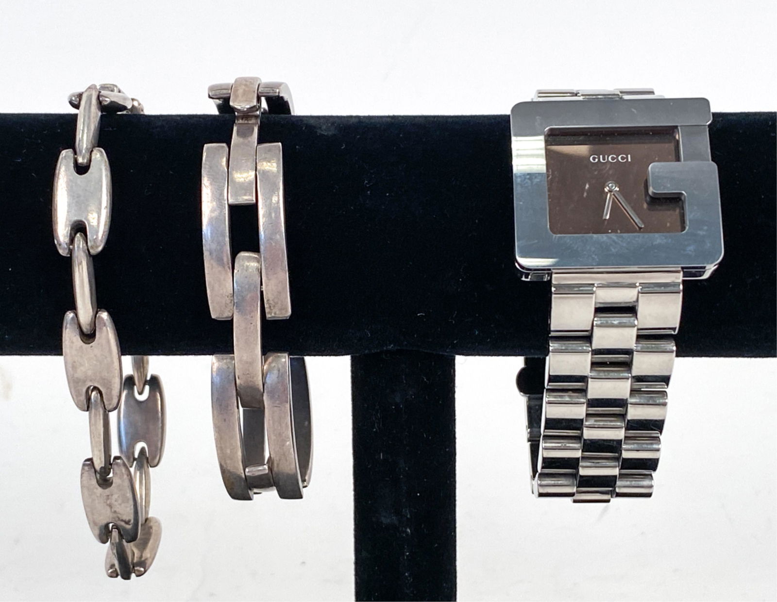 (2) VINTAGE GUCCI STERLING BRACELETS & G WATCH: Gucci stainless steel G watch with (2) vintage sterling silver link bracelets. Dimensions: Watch (Case) Width 31.6 mm Condition: Watch not currently running; may need new battery, movement not profess
