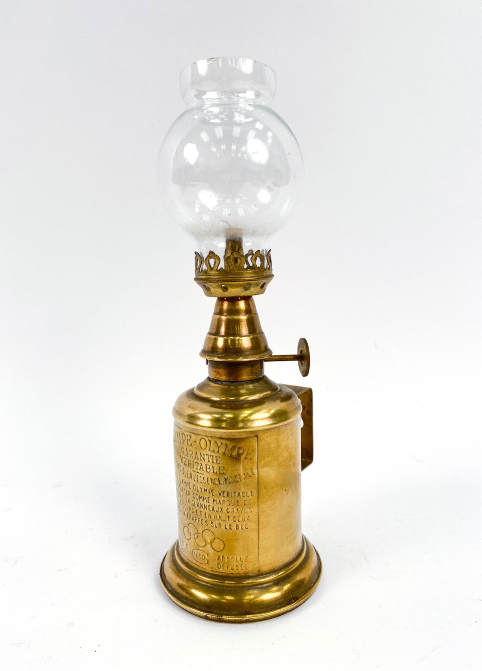 FRENCH ANTIQUE PETITE OLYMPIA PIGEON OIL LAMP: Produced to compete with the ubiquitous "Pigeon lamp" popular throughout France at the time. Few were made. Dimensions: H 9.5" x W 4" x D 3.25" Condition: Few small chips to hurricane shade. Some ligh