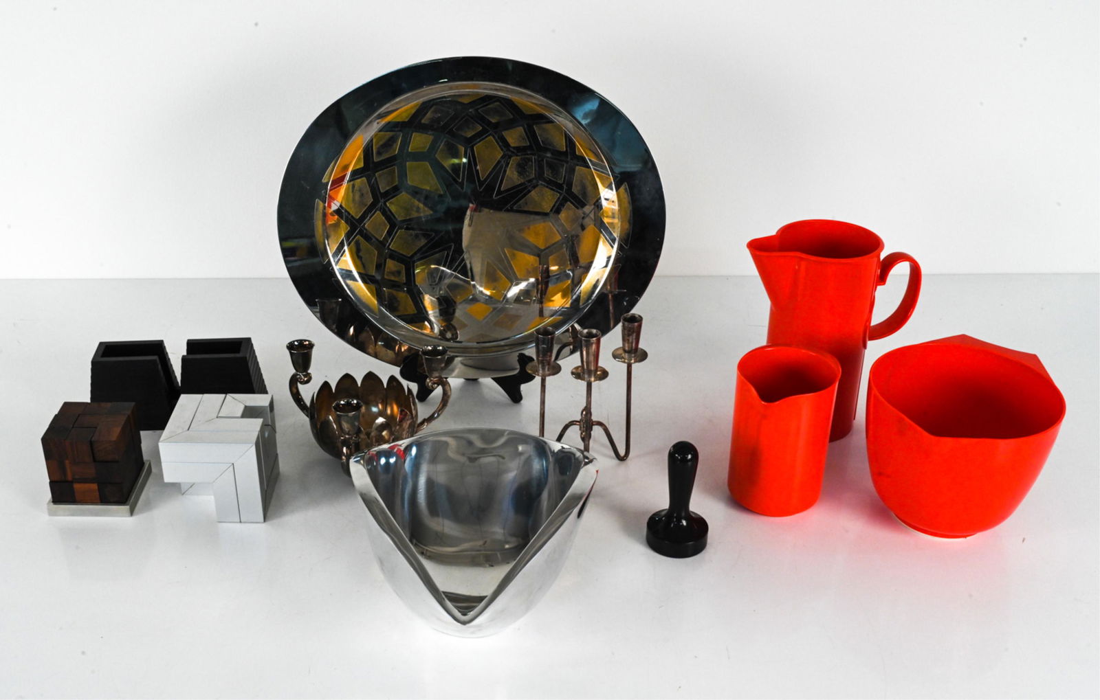 MID-CENTURY MODERN DECOR & TABLEWARE GROUPING: Including: Melamine serveware by Rosti and Dansk, a Skjode Skjern for Parker Bros. rosewood Soma cube puzzle, Nambe sculptural centerpiece bowl, Alessi two-tone platter, and various others. Dimensions