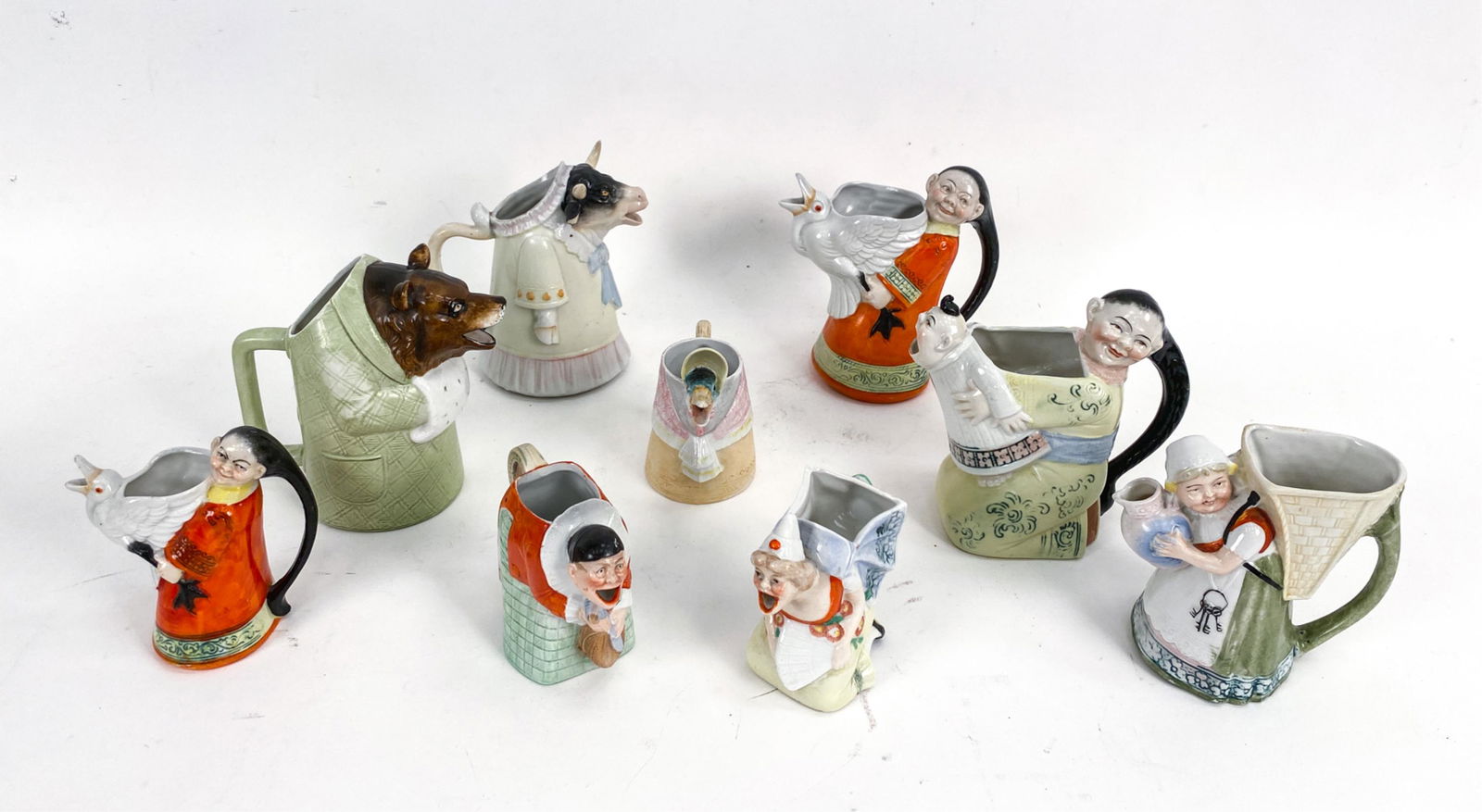 GERMAN ANTIQUE FIGURATIVE MUGS & CREAMERS: Some marked Germany, some unmarked. Dimensions: (Largest) H 5" x W 5.5" x D 3.5" Condition: Few very small nicks.