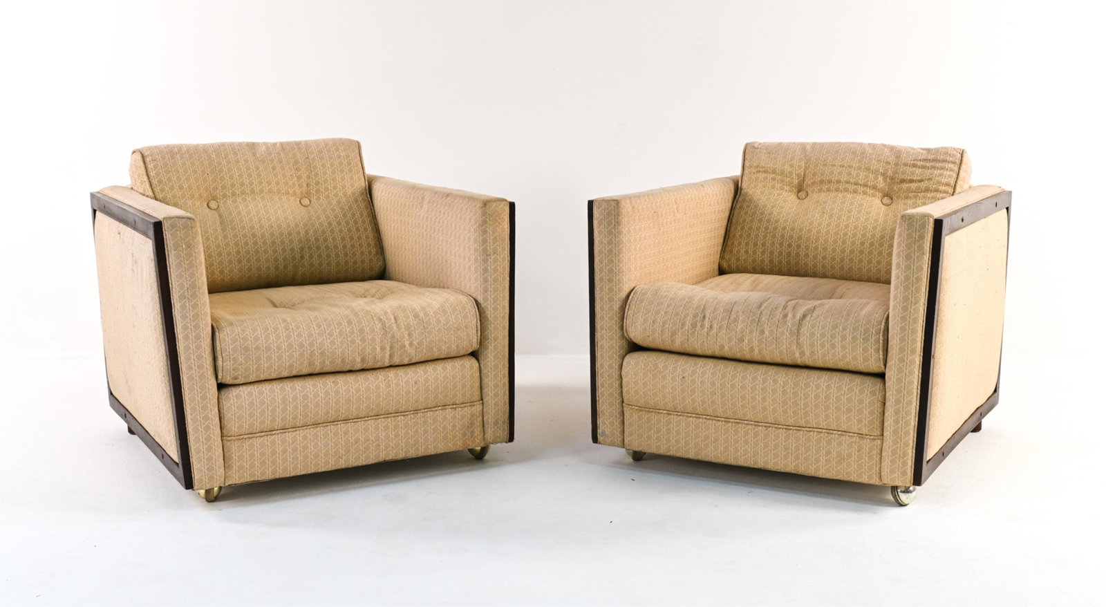 PAIR OF MID-CENTURY CUBE-STYLE CLUB CHAIRS: With wood trim and front casters. In the style of George Nelson. C. 1960's. Dimensions: H 25" x W 30.5" x D 24" x SH 17" Condition: Great candidates for refinishing; soiling and fading to upholstery; 