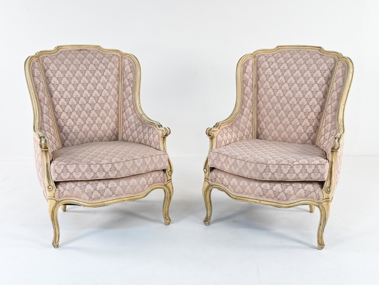 PAIR OF FRENCH PROVINCIAL-STYLE BERGERE CHAIRS: In distressed French white paint and lilac jacquard upholstery. Contemporary; apparently unlabeled. Dimensions: H 40" x W 28.5" x D 32" x SH 17.5" Condition: Intentionally distressed paint finish; wit