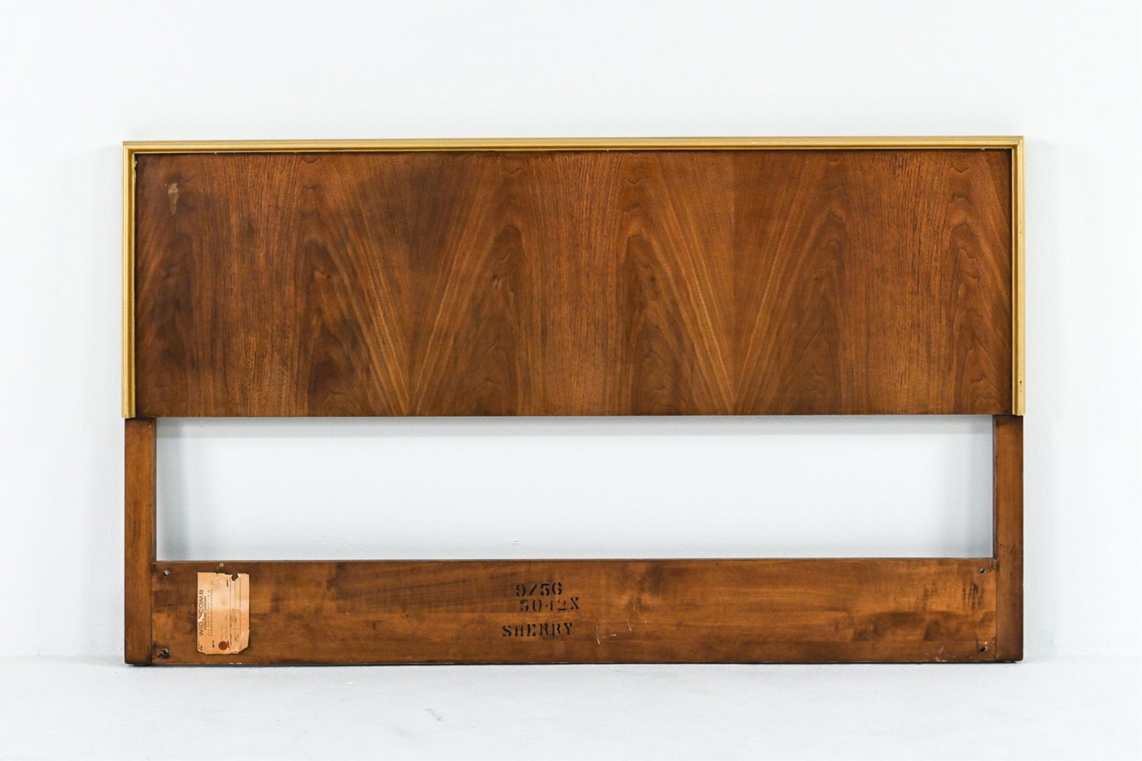 MID-CENTURY WIDDICOMB HEADBOARD: With "sherry" finish. With Widdicomb label. Faux gilt border. Dimensions: H 33.5" x W 56.5" x D 3" Condition: Light surface wear consistent with age and use.