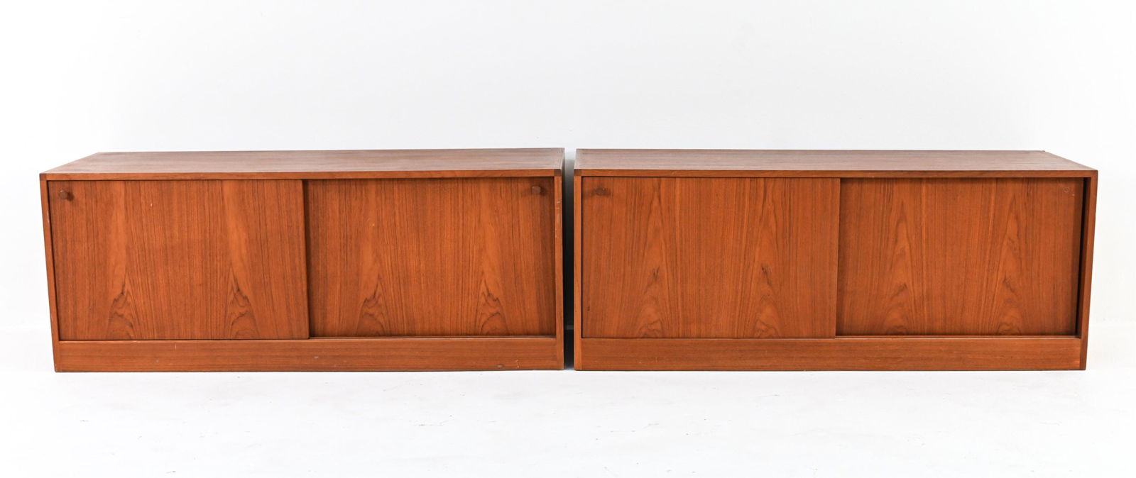 PAIR OF KURT OSTERVIG MODULAR TEAK CREDENZAS: Pair of Danish Mid-Century stacking media cabinets in teak wood, designed by Kurt Ostervig for KP Mobler c. 1960's. Dimensions: (Single cabinet) H 18.25" x W 46.25" x D 17.75" Condition: Dent and loss