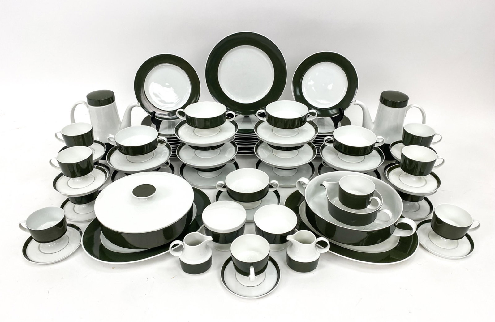 TAPIO WIRKKALA PORCELAIN SERVICE FOR ROSENTHAL: Marked underneath. Includes: 11, 10" plates, 23, 7.75" plates, 11, 7" saucers, 11, 5" saucers, 11 pedestal bowls 6.5" diameter with handles, 13, 4" diameter with handle cups, 1 lidded serving bowl 8.7