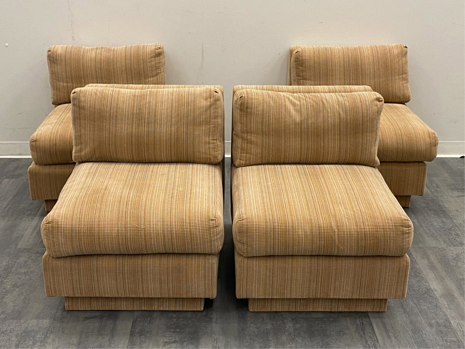 (4) MID-CENTURY MODULAR SLIPPER CHAIRS: Four Modernist modular chairs with clean geometric lines. Seats sit atop a plinth base. Dimensions: (Each) H 28.5" x W 25.5" x D 35" x SH 16" Condition: Minor surface wear consistent with age and use.