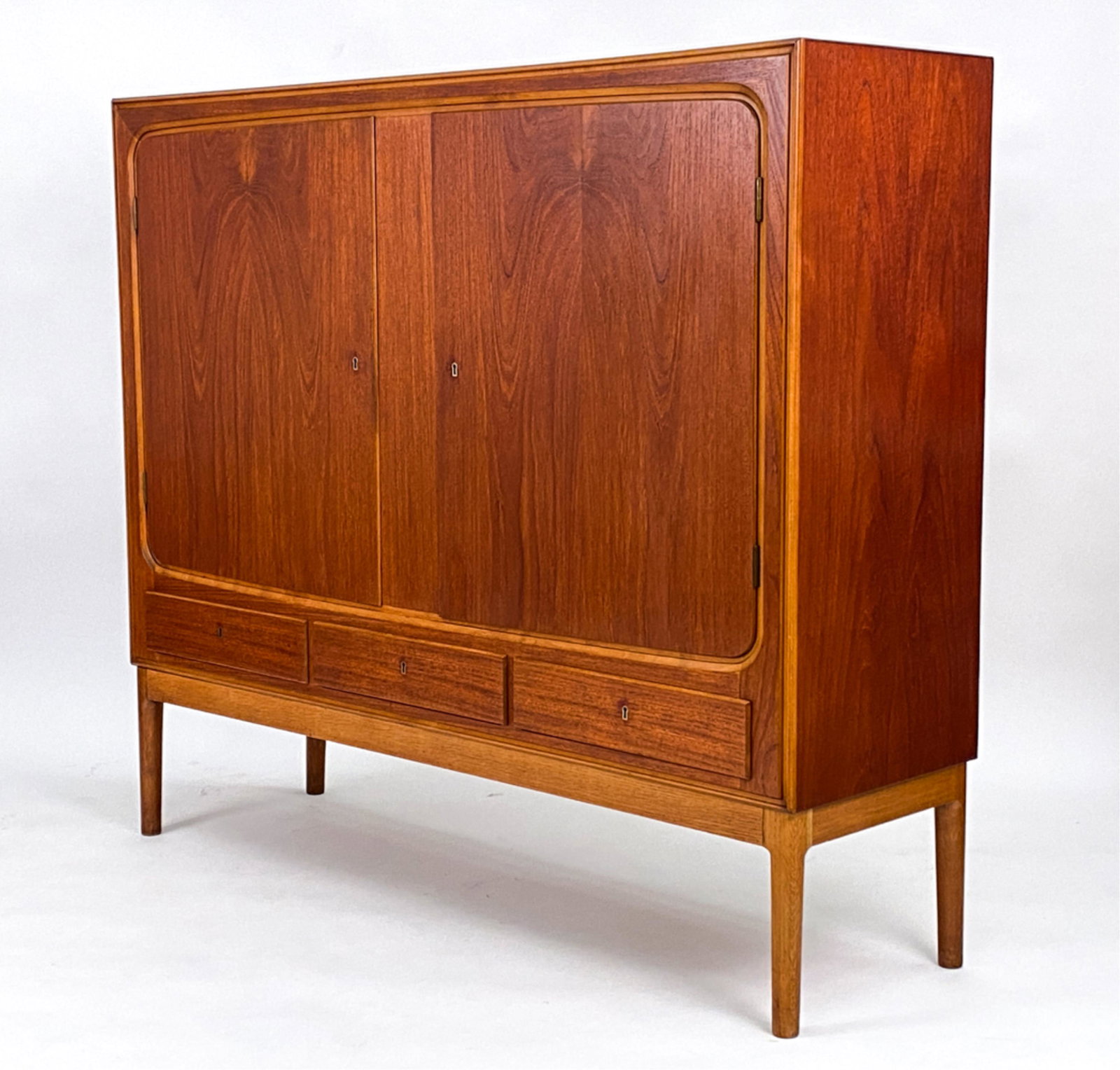 DANISH 1960'S TEAK SIDEBOARD: Dimensions: H 51.75" x W 59.25" x D 17.25" Condition: Repair to door. Overall light wear consistent with age. Proper right side cabinet door escutcheon is loose. A few small scattered marks. A065