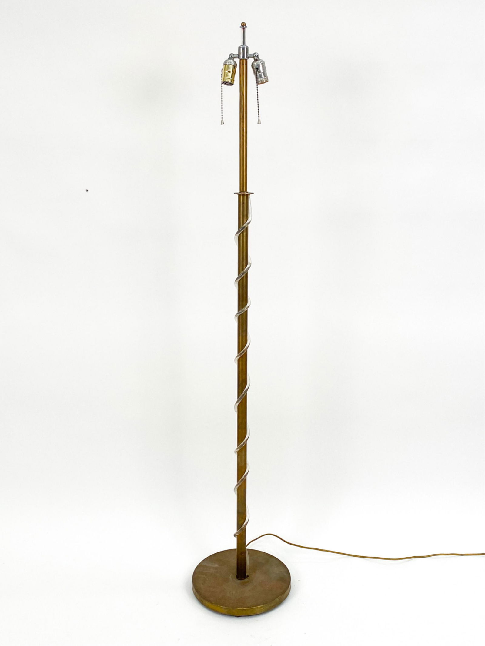 MID-CENTURY BRASS & LUCITE TWIST FLOOR LAMP: Apparently unsigned. Brass floor lamp with coiled lucite swirl. Dimensions: (To finial) H 63.5" x Dia 12" Condition: Tarnish and wear to brass finish. Light fixture stem attached loosely to base.