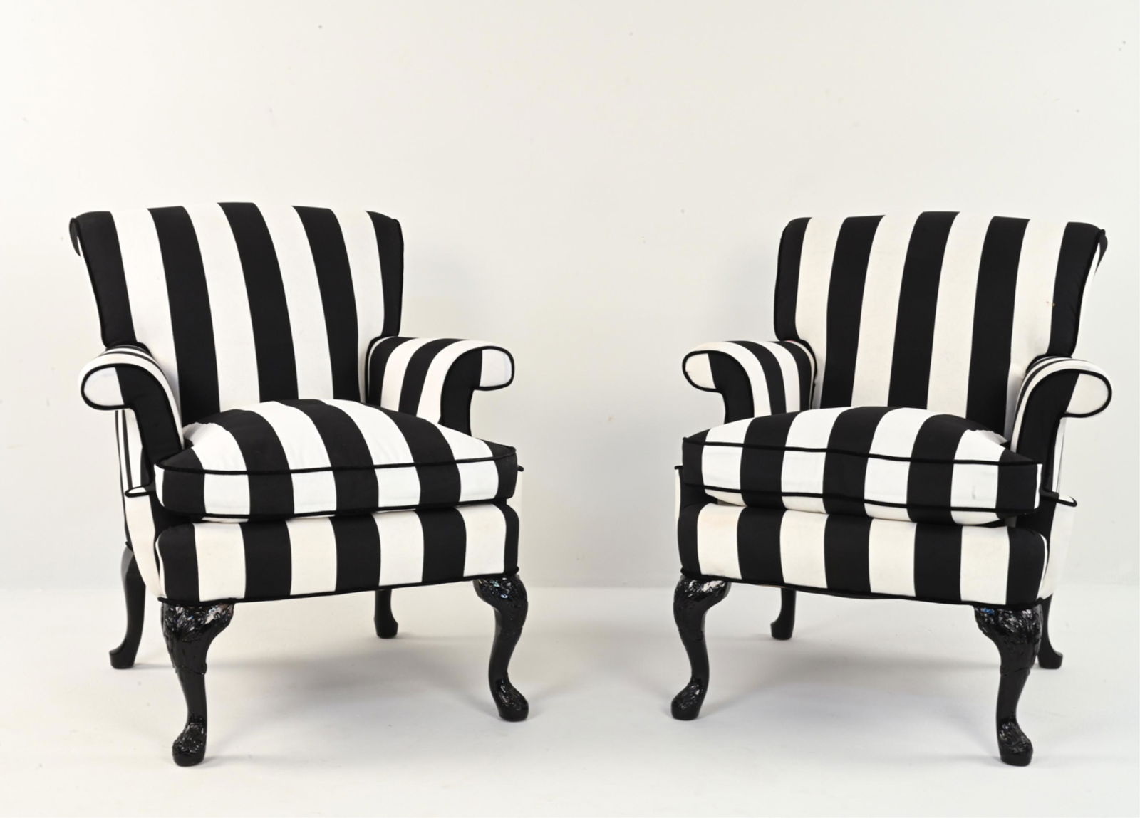 PAIR OF BOLD BLACK & WHITE STRIPED LOUNGE CHAIRS: With rolled back and arms. Black-painted carved legs. Bold black and white striped fabric. Dimensions: H 36" x W 32" x D 34" x SH 19.5" Condition: Recently refinished and reupholstered. Few small hand
