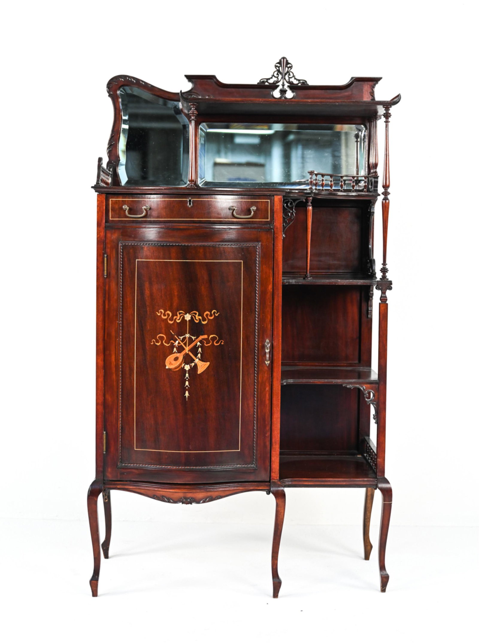 EDWARDIAN ART NOUVEAU MAHOGANY MUSIC CABINET: Early 20th Century mahogany cabinet featuring beveled mirror panels and open tiered shelves adorned with delicate spindled galleries and reticulated carved braces, the door decorated with mother-of-pe