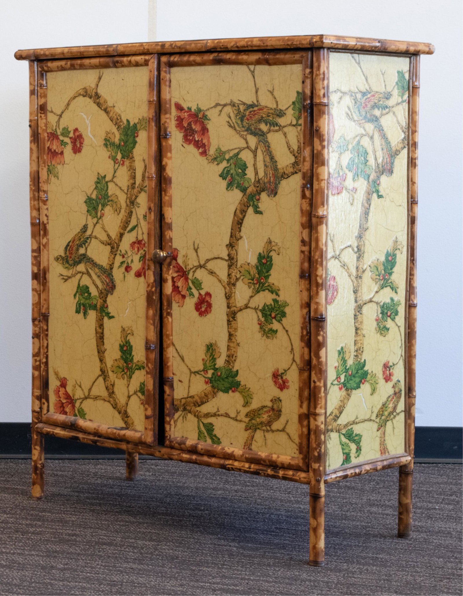 LILLIAN AUGUST CHINOISERIE DECOUPAGE CABINET: With yellow crackle finish. Tortoiseshell bamboo trim. Lillian August label to back corner. Dimensions: H 42.5" x W 37.5" x D 15" Condition: Few areas of finish loss to yellow crackle finish. Intentio