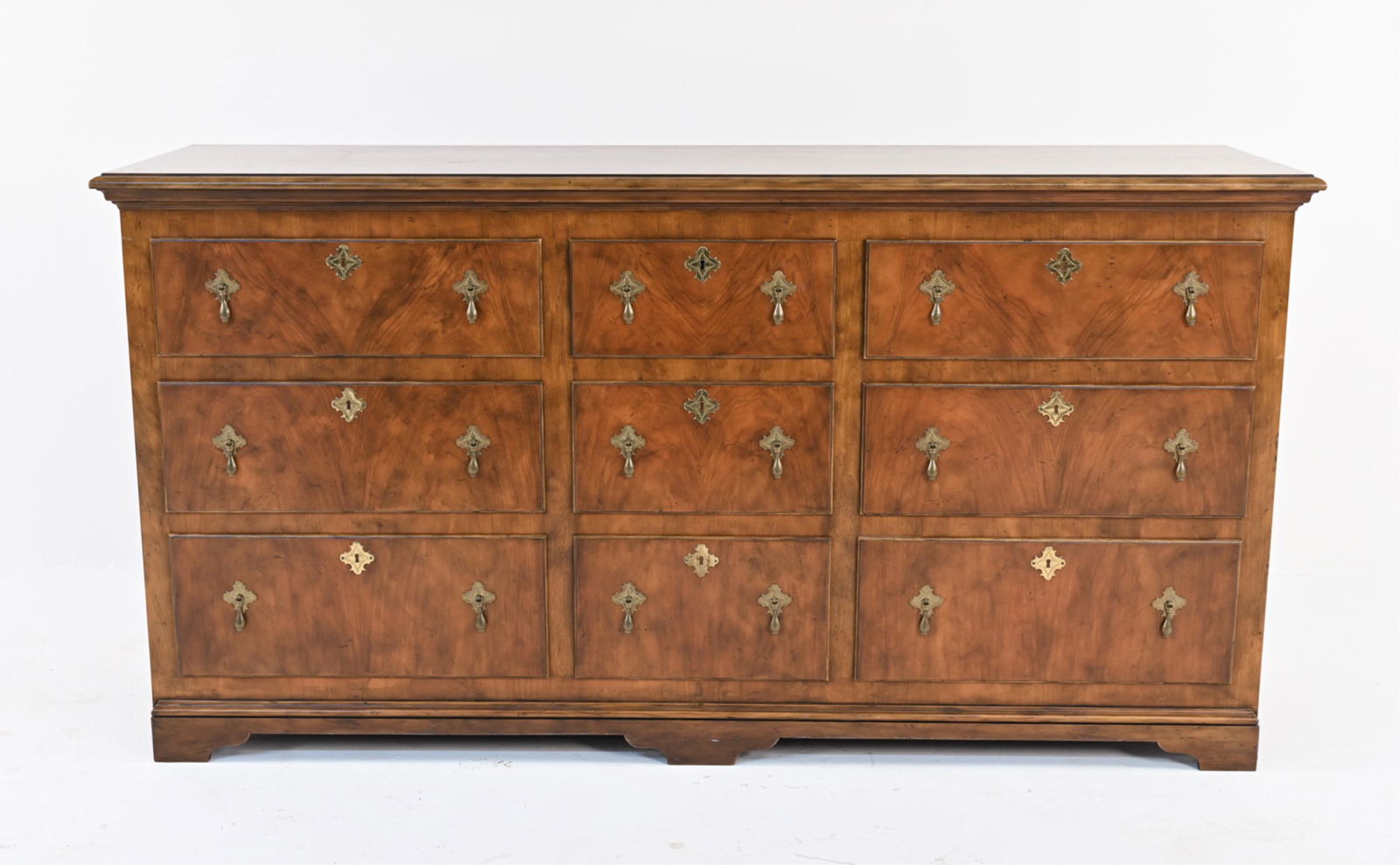BAKER FURNITURE BURLWOOD CHEST OF DRAWERS: Lowboy dresser in the George I style, with nine dovetailed drawers, burl veneer fronts and brass pendant pulls. Marked Baker Furniture on plaque in drawer, c. Mid- to Late 20th Century. Dimensions: H