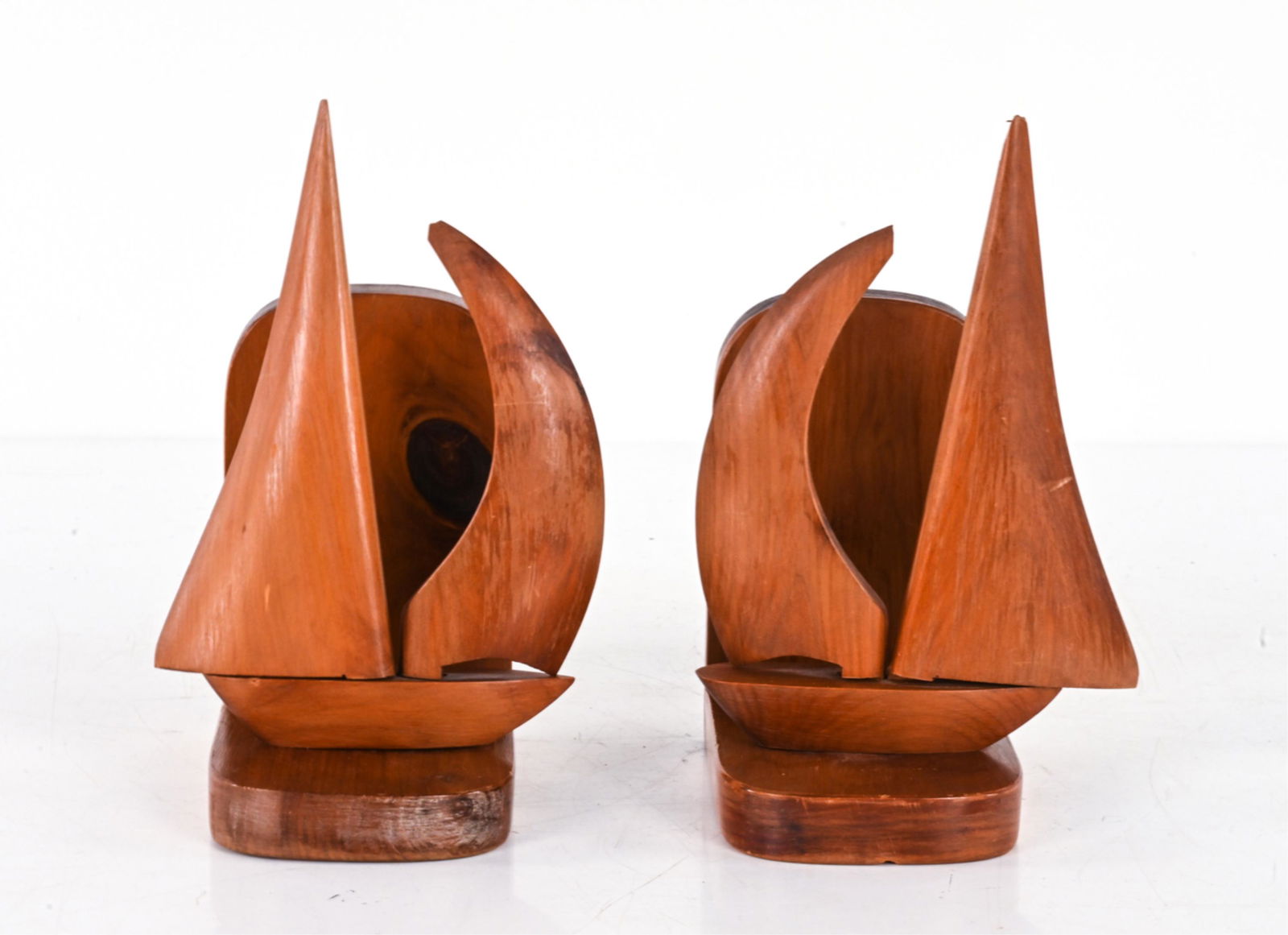PAIR JOHN E.M. DAVIS BERMUDIAN CEDAR SHIP BOOKENDS: Signed underneath, with inscription/titles. Dimensions: H 8.5" x W 4" x D 5.75" Condition: Both with small chips to corners of sails. Some finish wear. Sails loose in base holes, one with small piece
