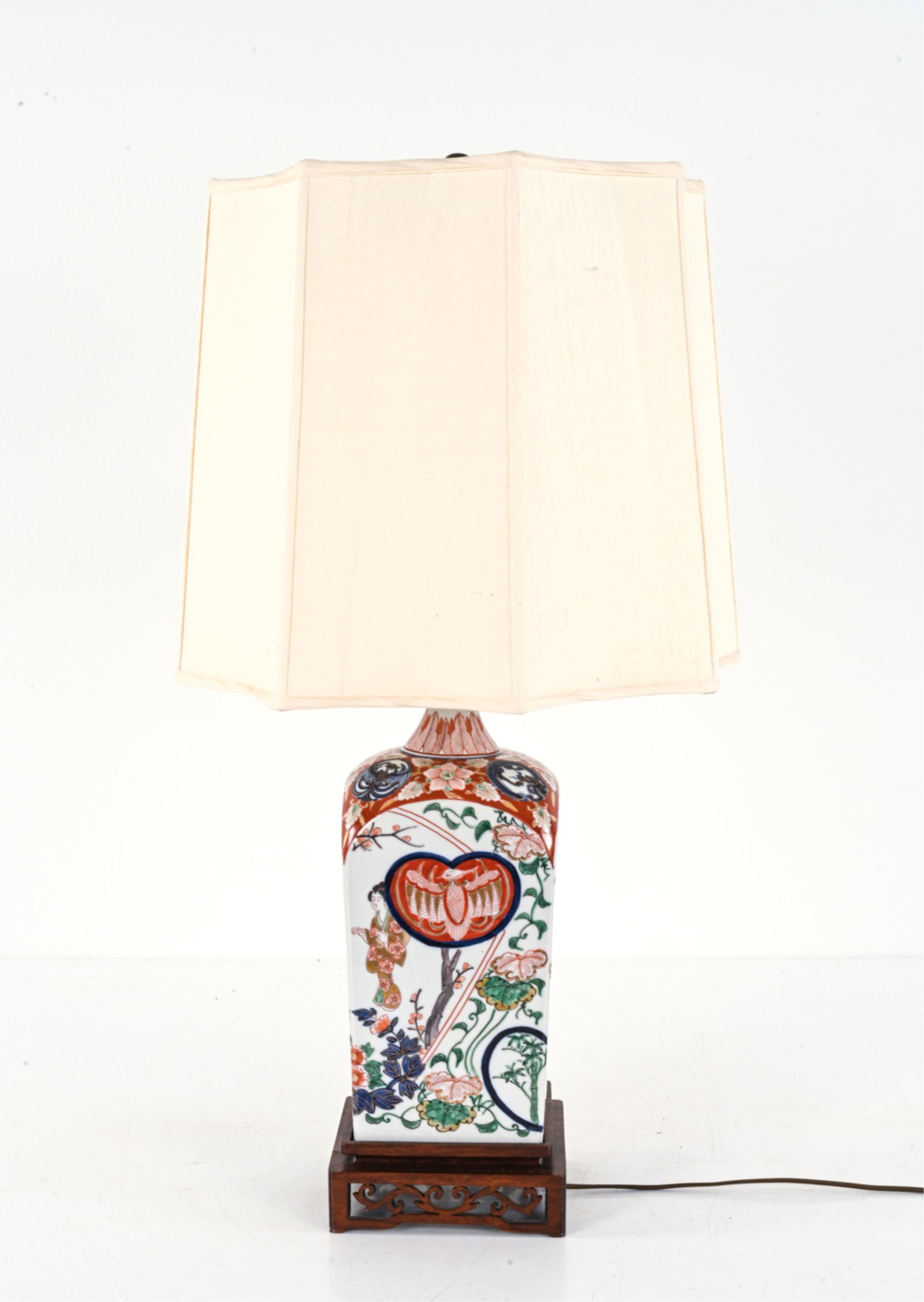 JAPANESE PORCELAIN BOTTLE, AS LAMP: 20th Century. Dimensions: (Without shade) H (to finial) 25" x W 5.5" x D 5.5" Condition: Wiring not tested. A few rubs to porcelain decoration; tears to shade. Wood base with small break to carving.