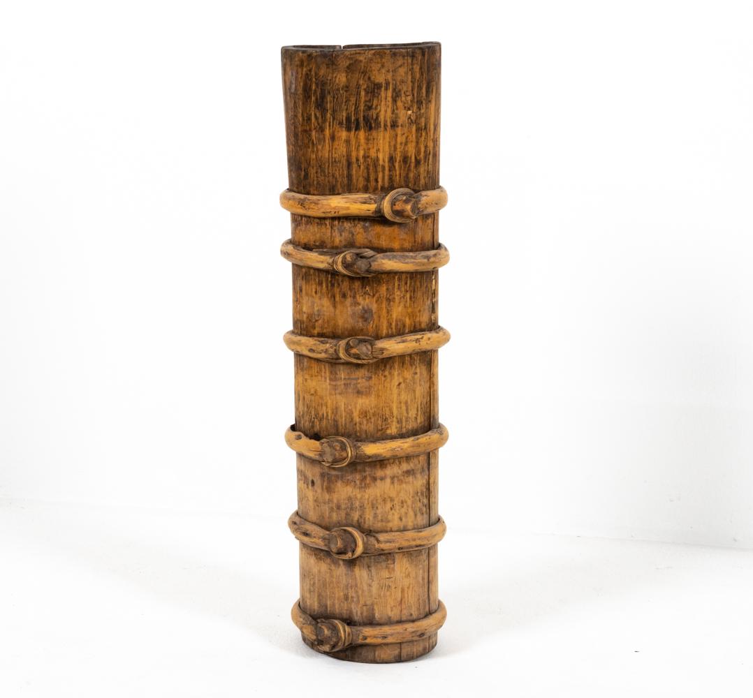 TIBETAN YAK BUTTER CHURN / BARREL: Tall Tibetan yak butter churn or barrel with knotted bentwood straps. Dimensions: H 30.5" x Dia. 8" Condition: Rustic wear consistent with age and use including splits to wood.